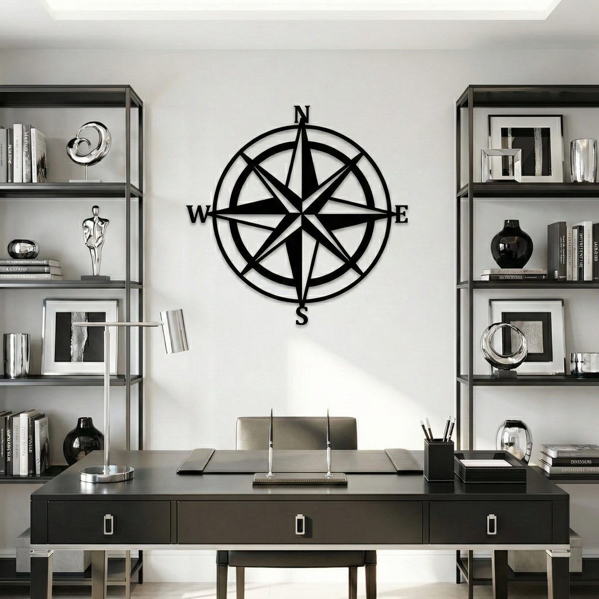Black compass wall decoration in a modern office setting with bookshelves and a desk.