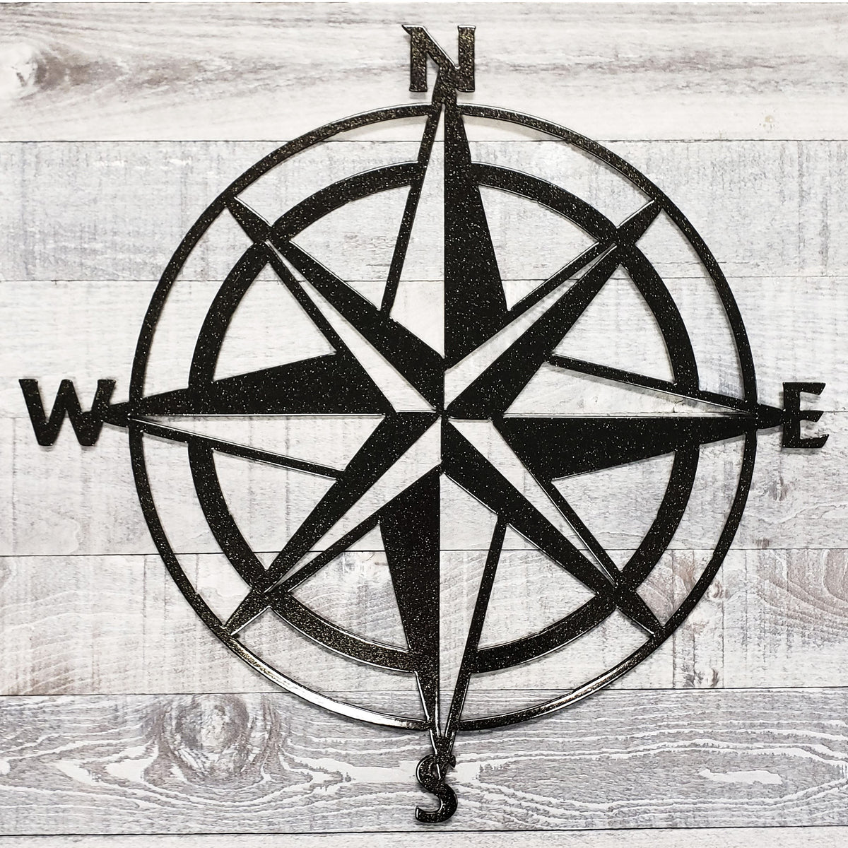 Black compass rose on a wooden background