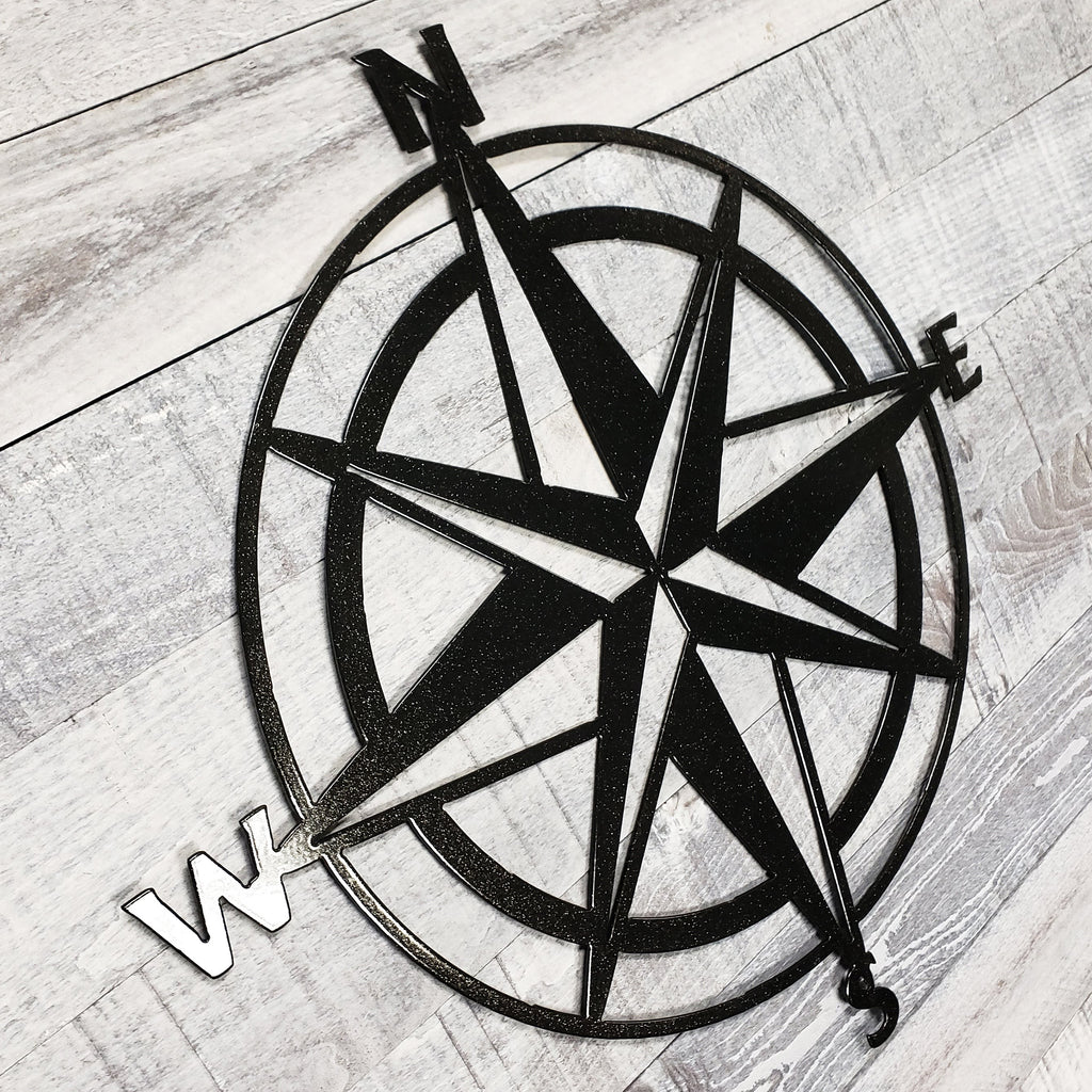 Black compass rose on a wooden surface