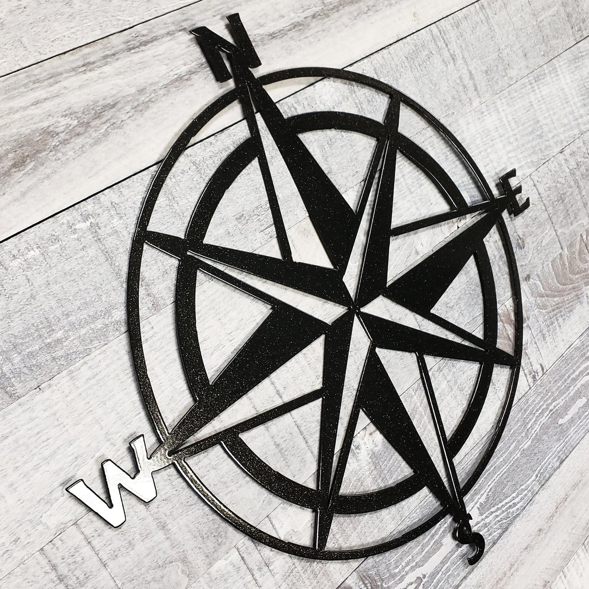 Black compass rose on a wooden surface
