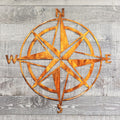 Copper colored compass wall decor on a wooden background