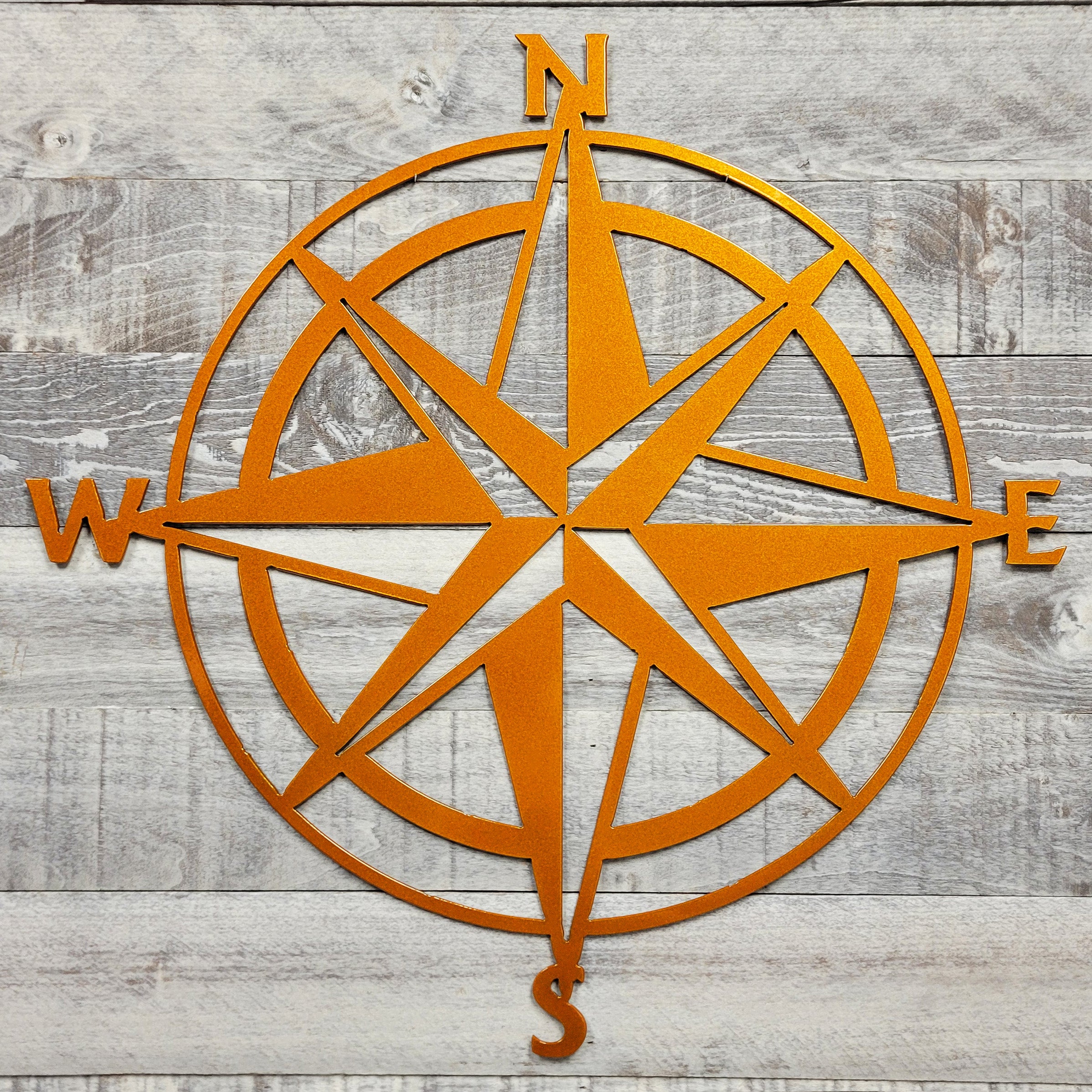 orange compass wall decor on a wooden background