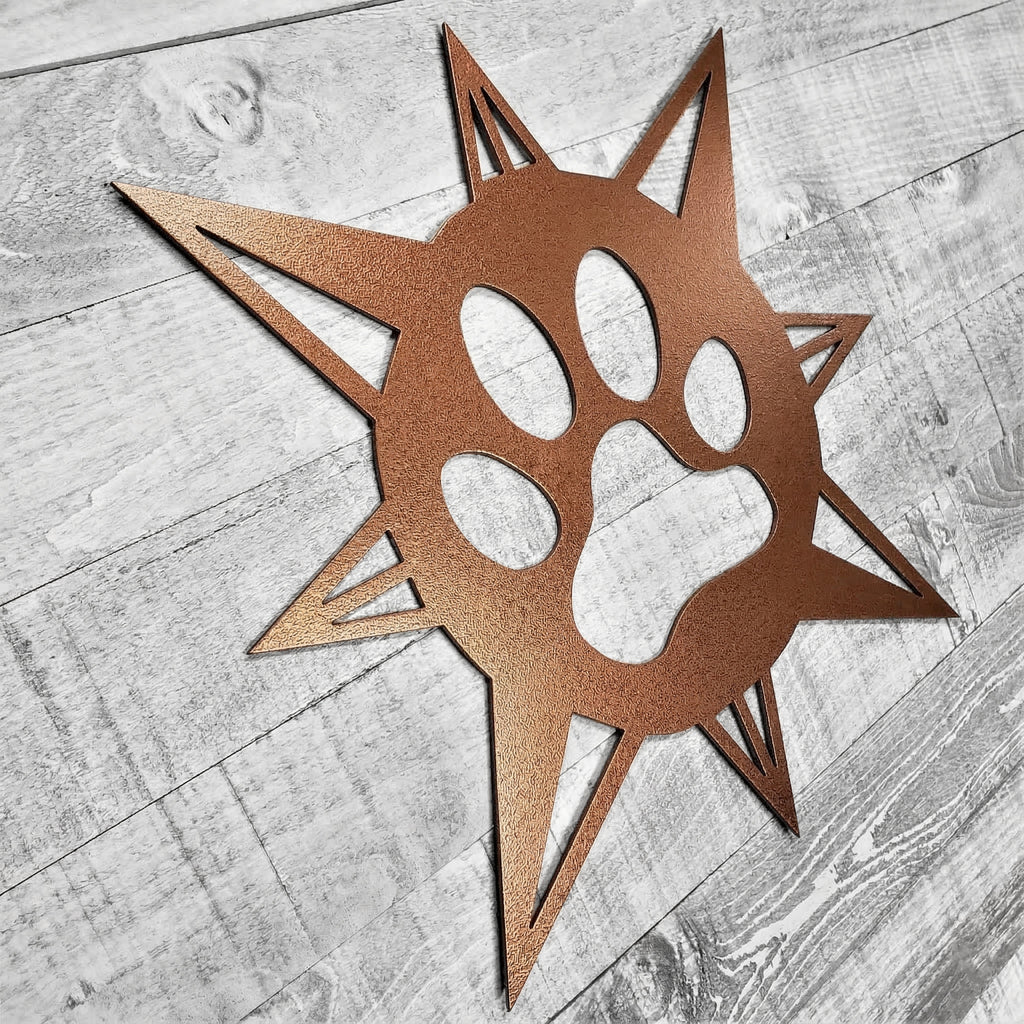copper-colored compass rose with dog paw in center on a wooden background