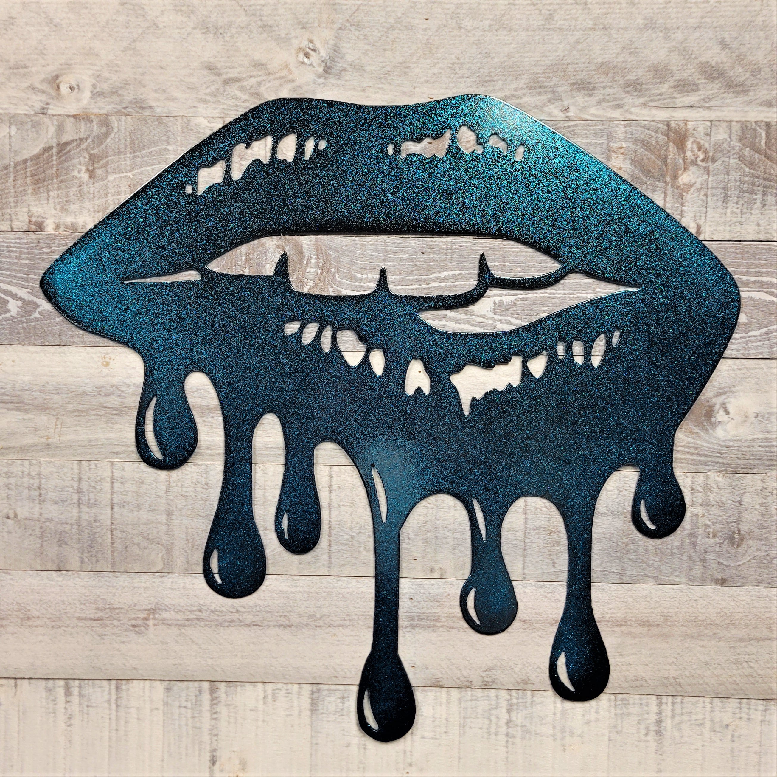 Metallic blue lips with dripping effect on a wooden background