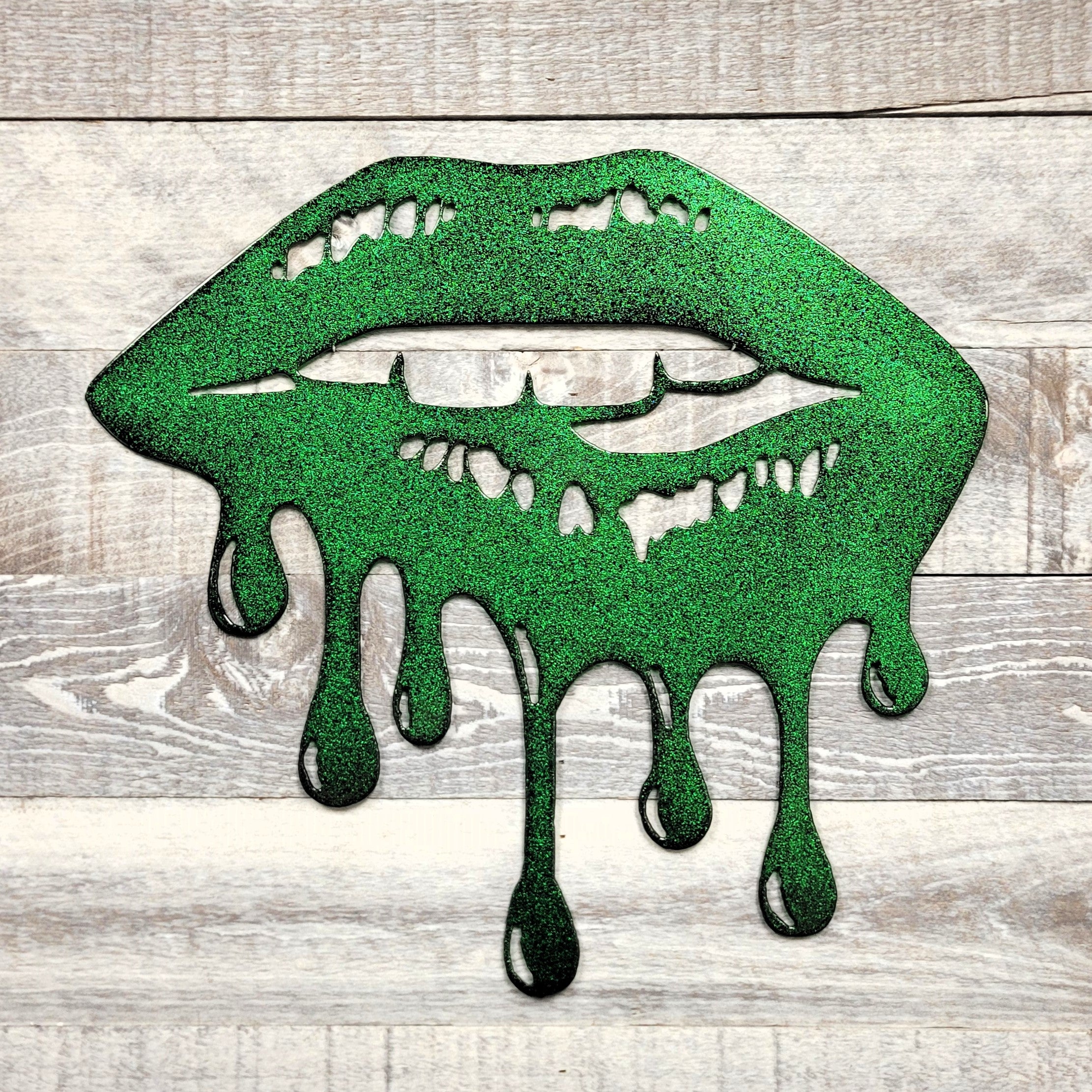 Green metallic lips with dripping effect on a wooden background