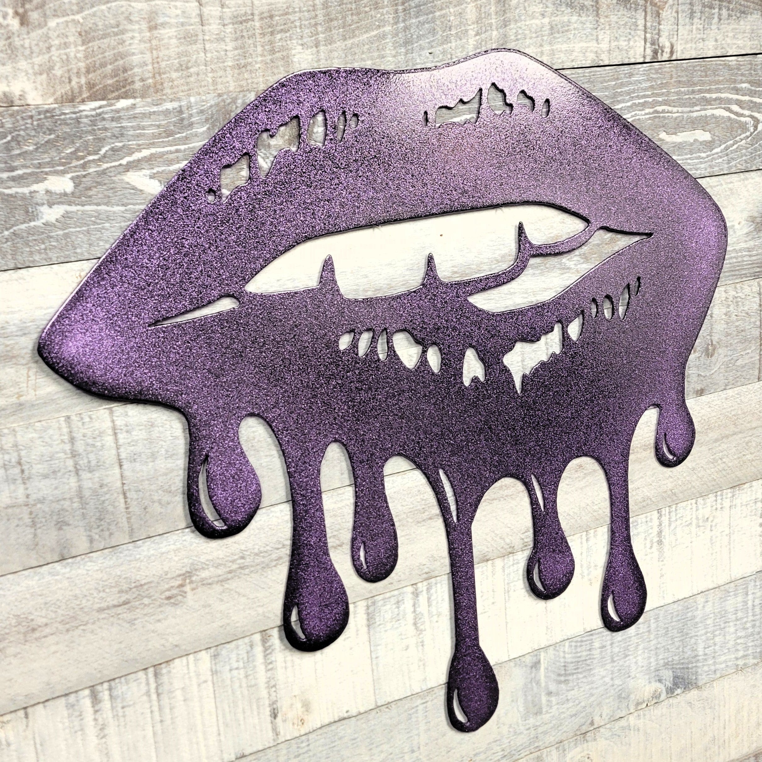 Metallic purple lips with a dripping effect on a wooden surface