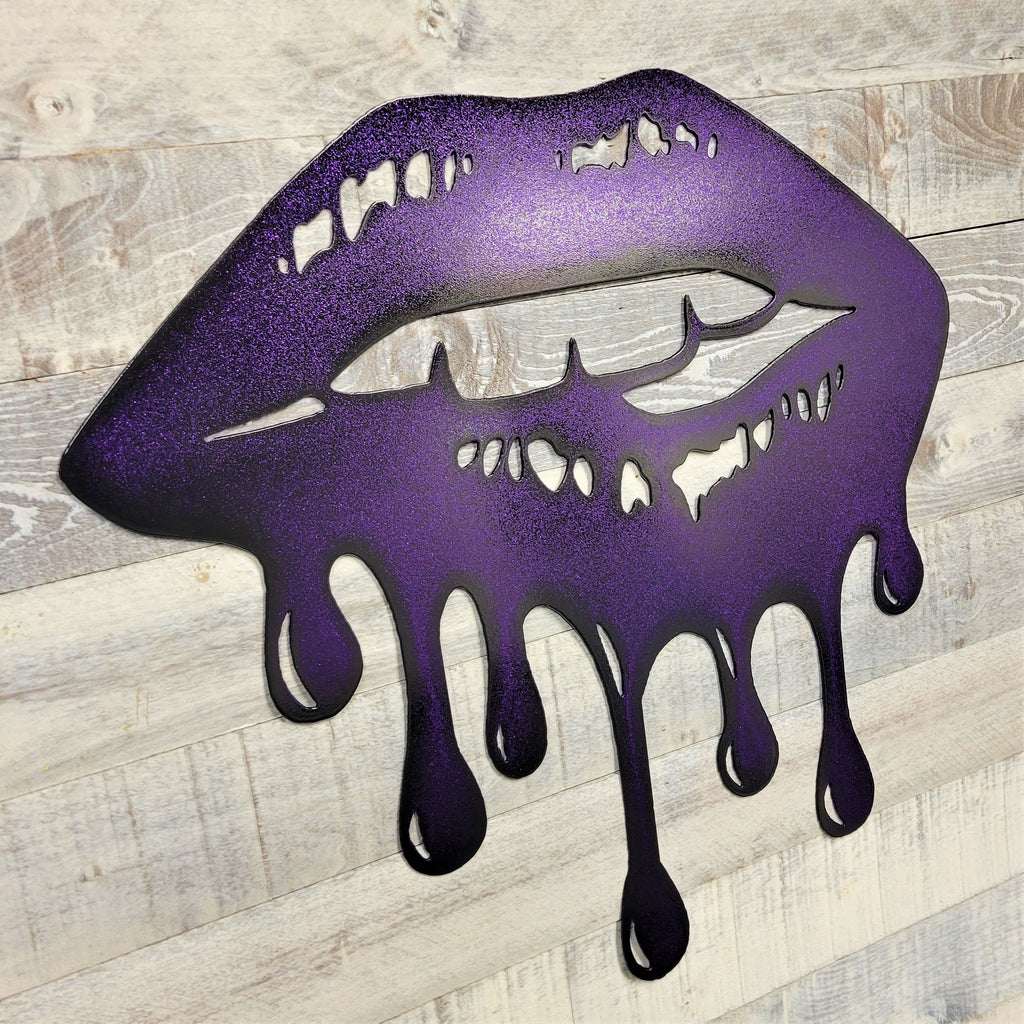 Metal wall art of purple lips with dripping effect on a wooden background