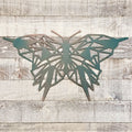 geometric representation of a butterfly with a copper and teal color finish on a wooden background