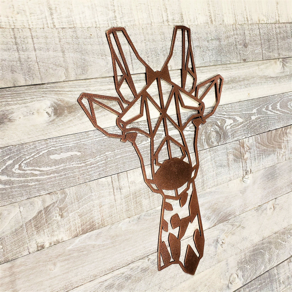 Geometric metal giraffe wall art on a wooden surface