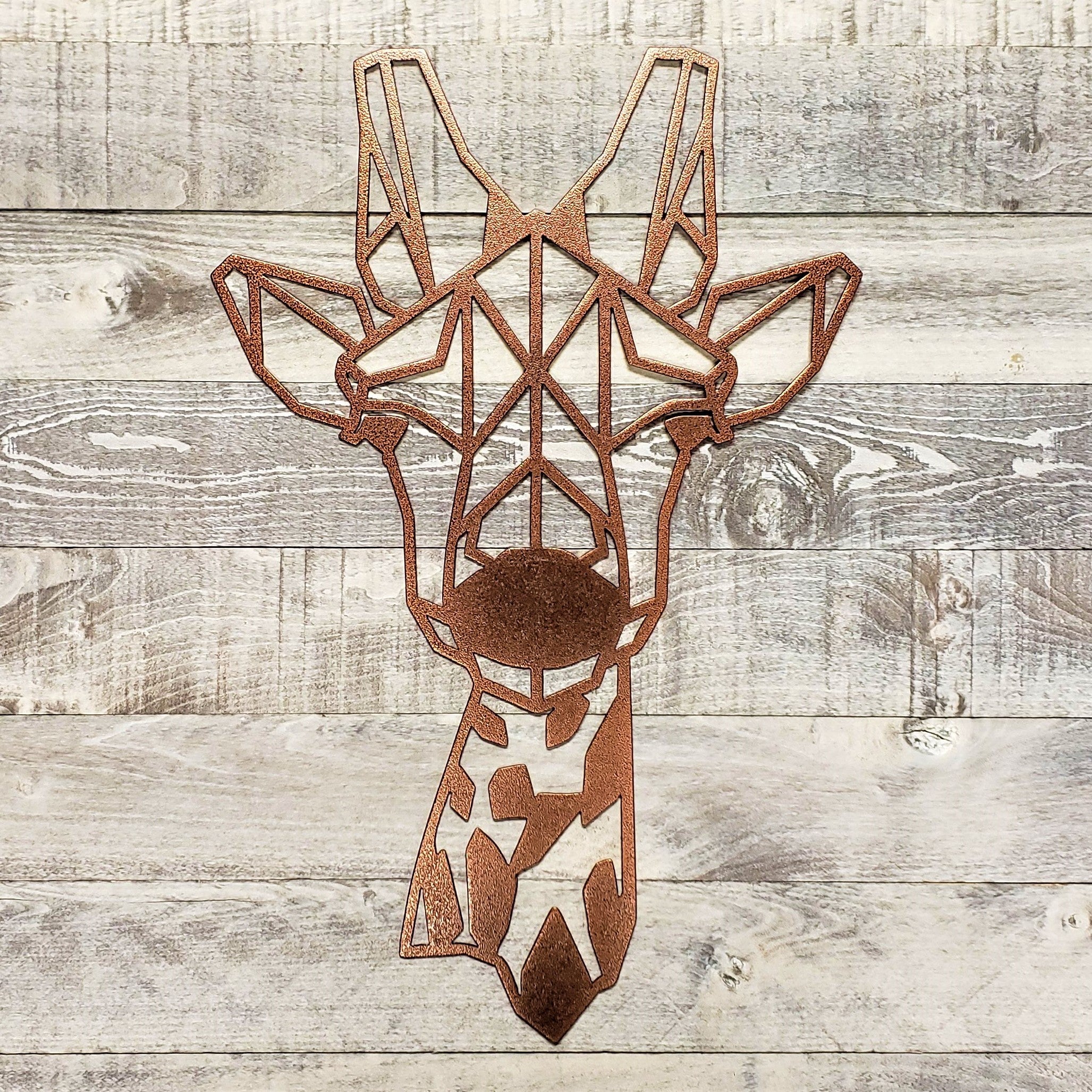 Geometric metal giraffe wall art on a wooden background