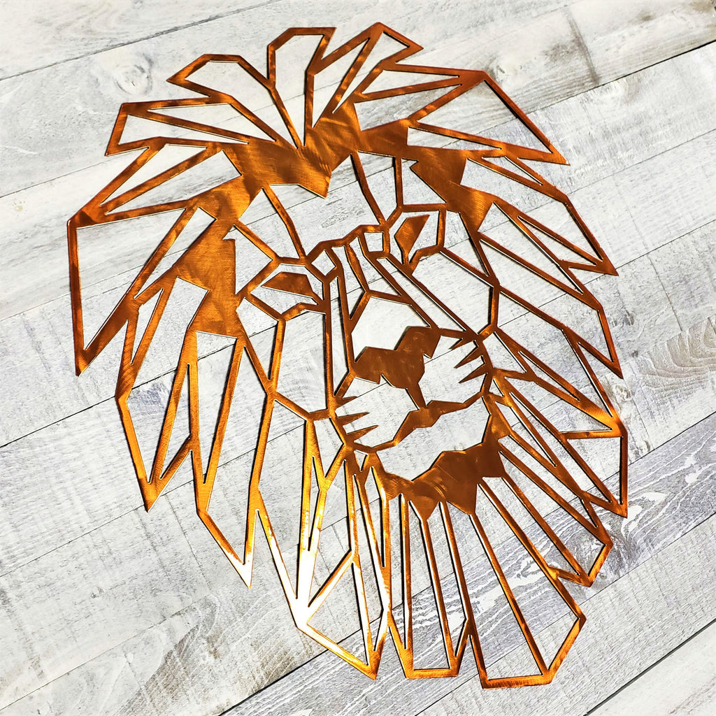 copper colored geometric lion head wall art on a light wooden floor.