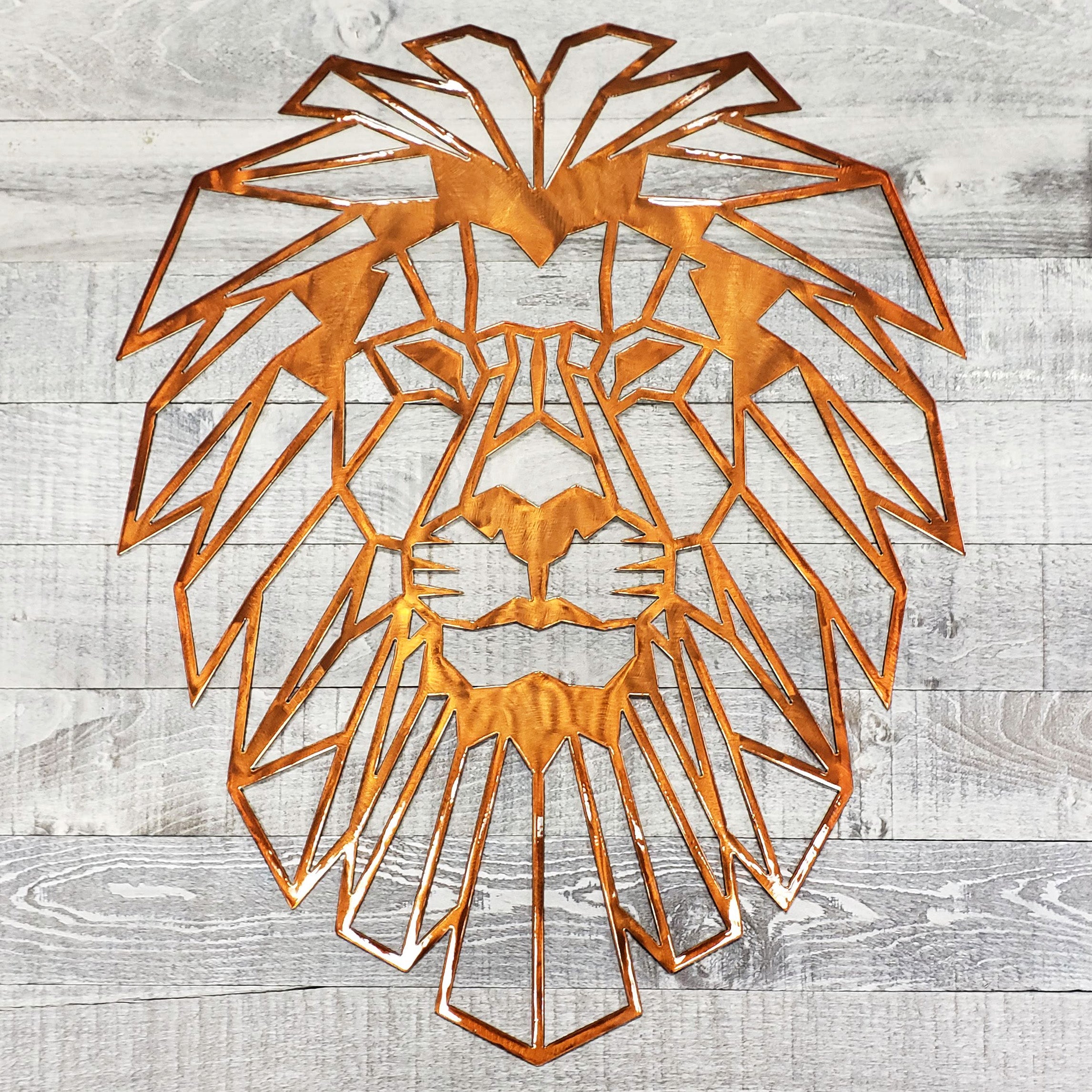 Geometric metal lion head wall art on a wooden background