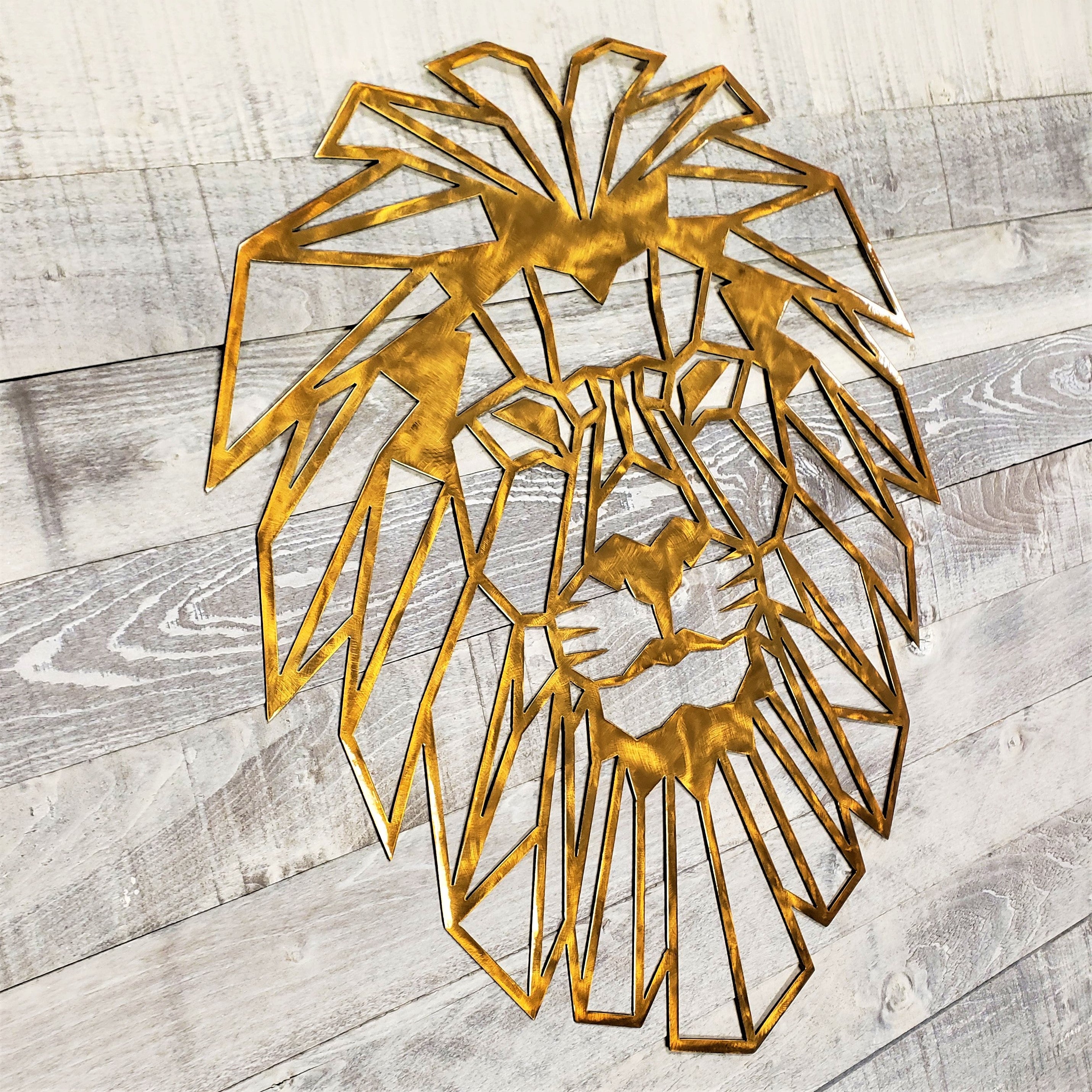 Gold geometric lion head wall art on a wooden surface
