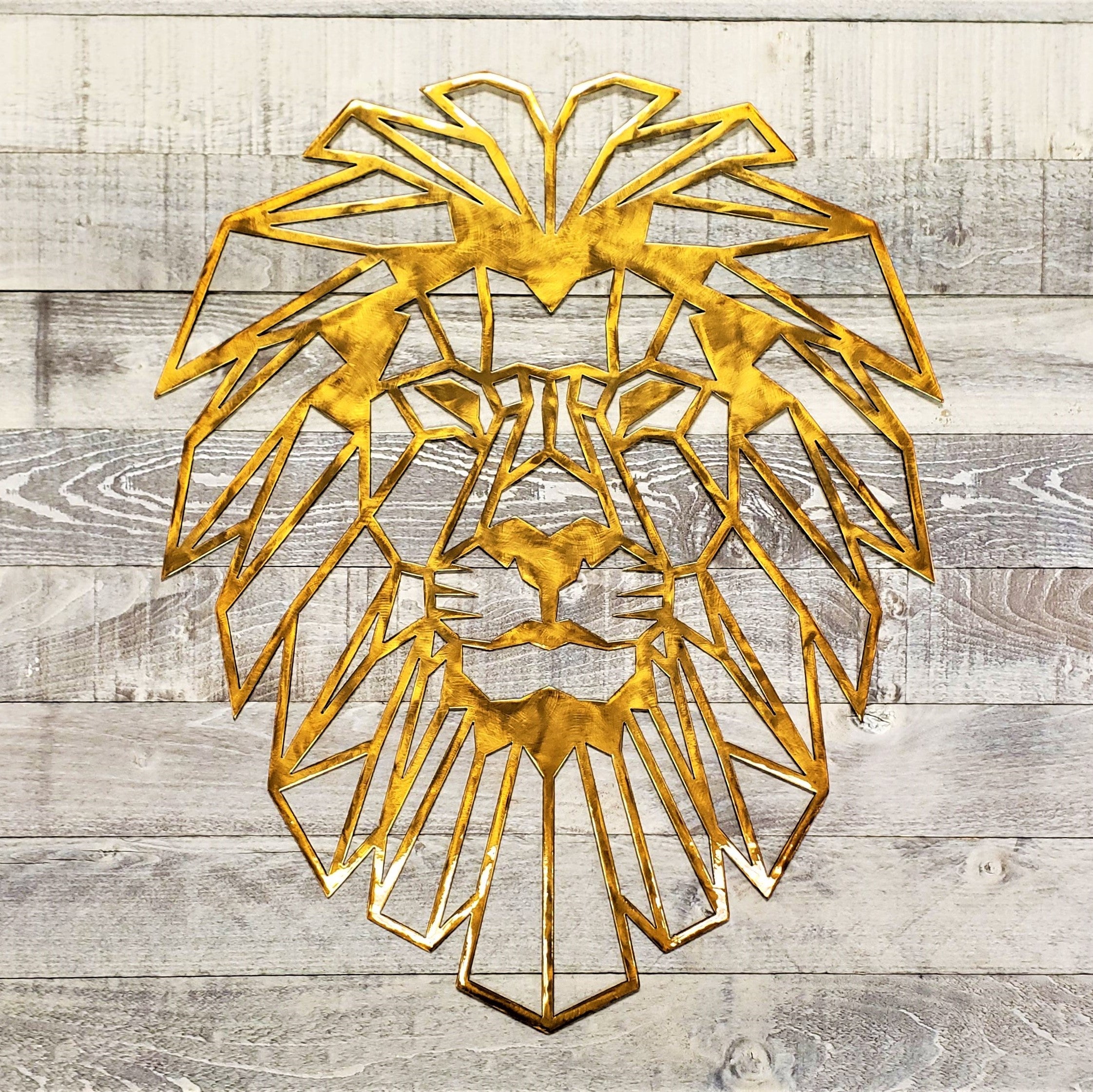 Gold lion head wall art on a wooden background