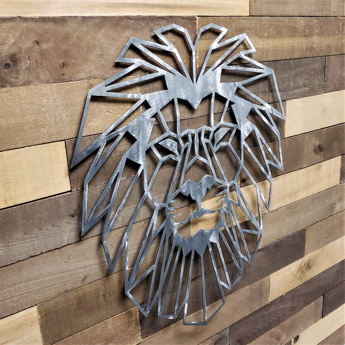 Metal lion head wall art on a wooden panel background