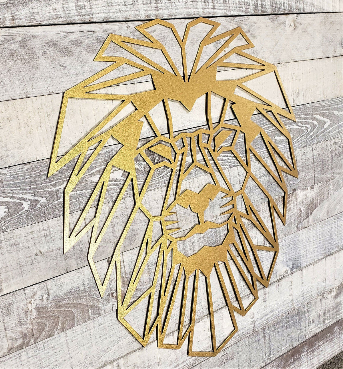 Gold geometric lion head wall art on a wooden background