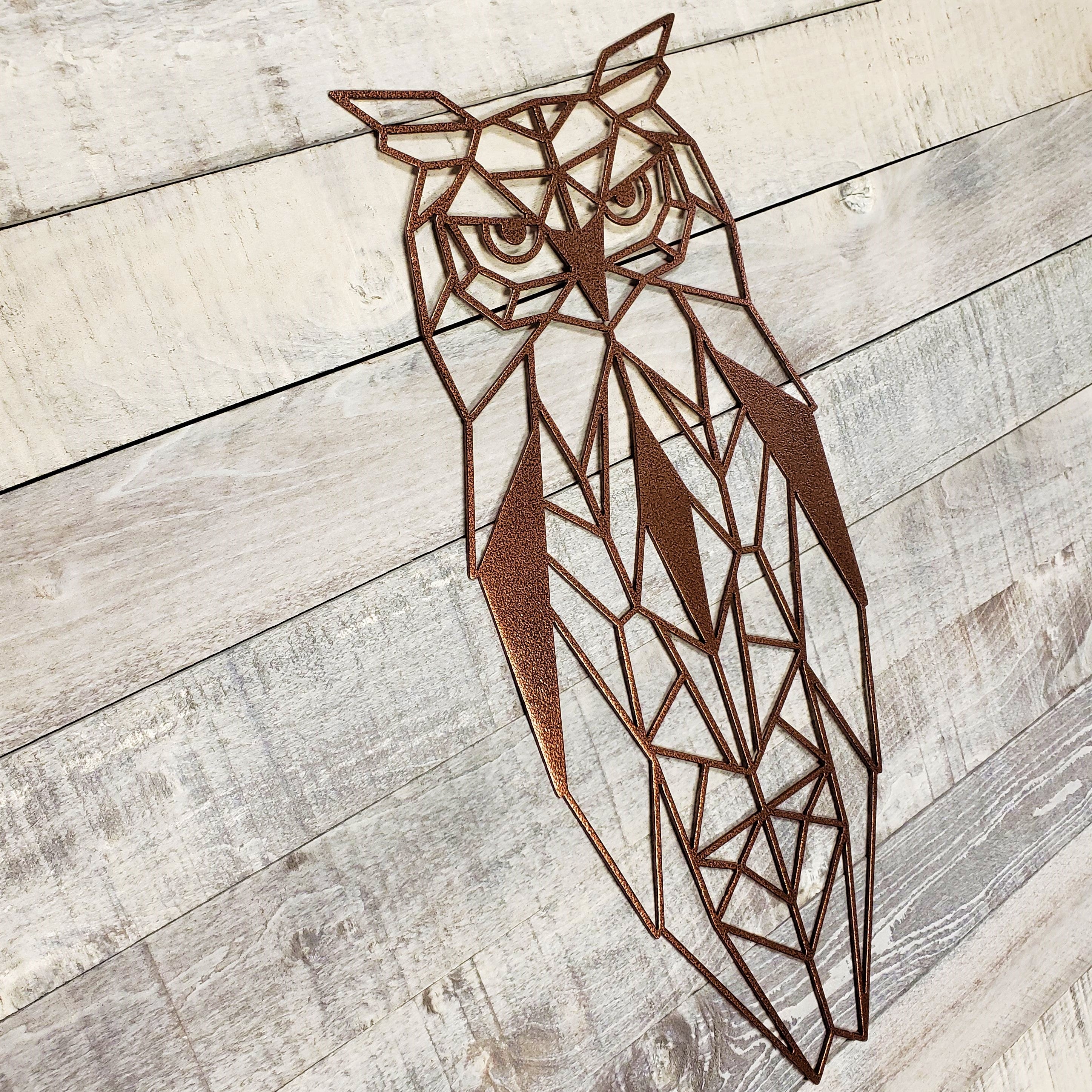 antique copper geometric owl metal wall art on a wooden background