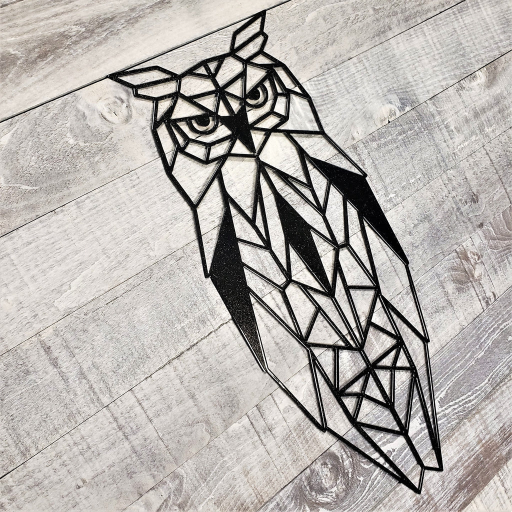 black geometric owl metal wall art on a wooden background