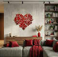 Living room with a gray sofa, red decorative pillows, and a heart-shaped wall art piece.