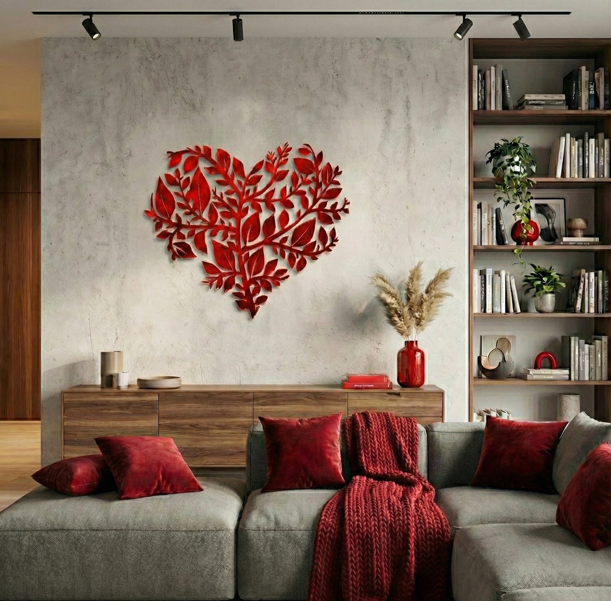 Living room with a gray sofa, red decorative pillows, and a heart-shaped wall art piece.