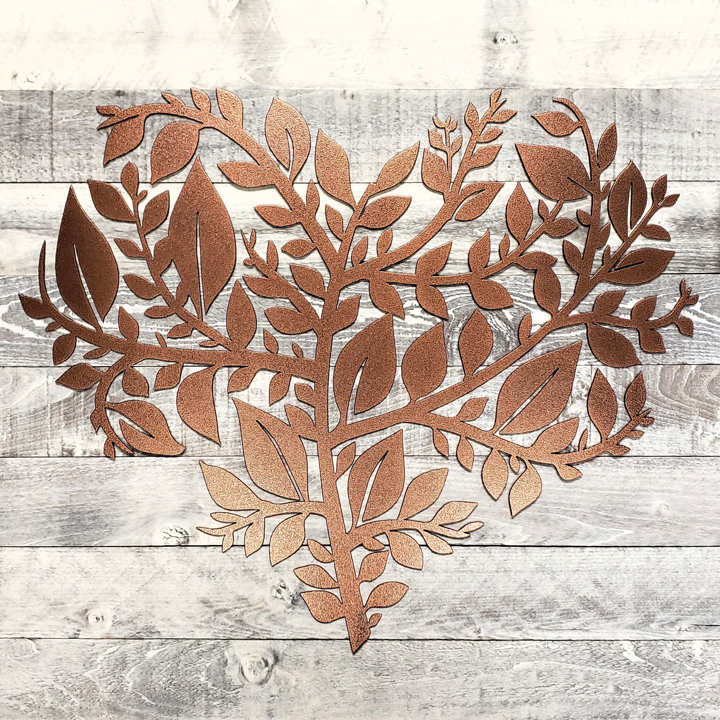 Decorative metal leaf design on a wooden surface