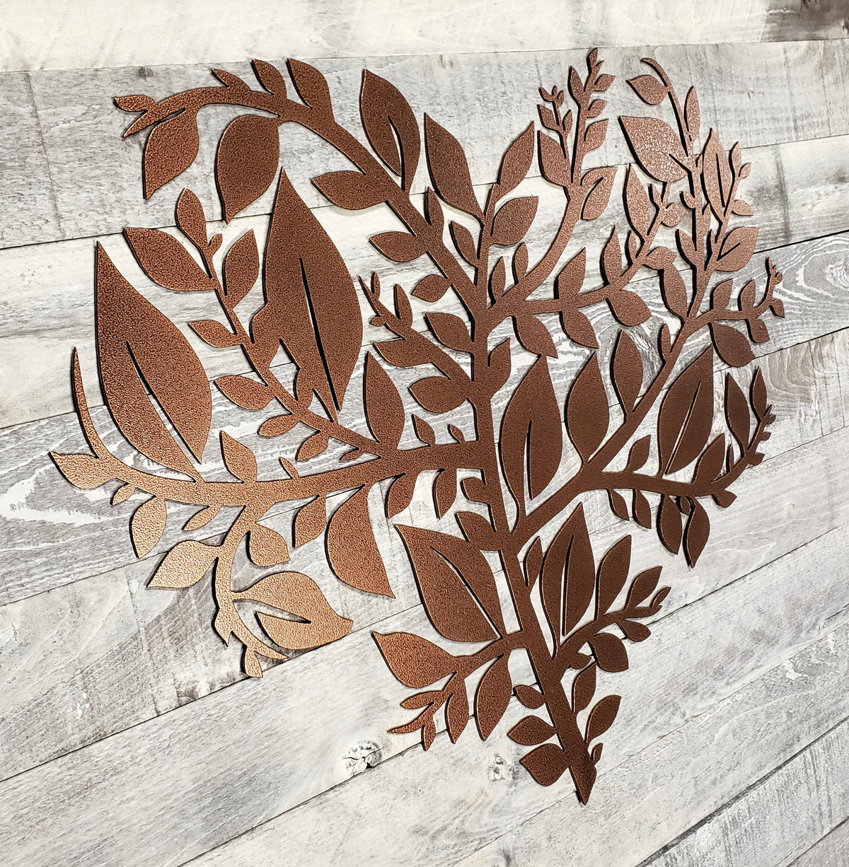 Decorative metal leaf design on a wooden surface