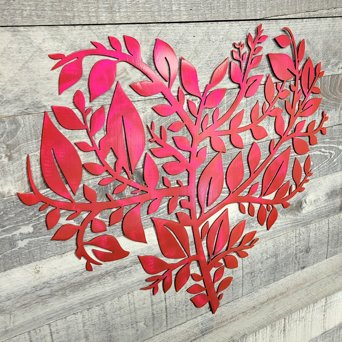 pink leaf-shaped cutout on a wooden surface