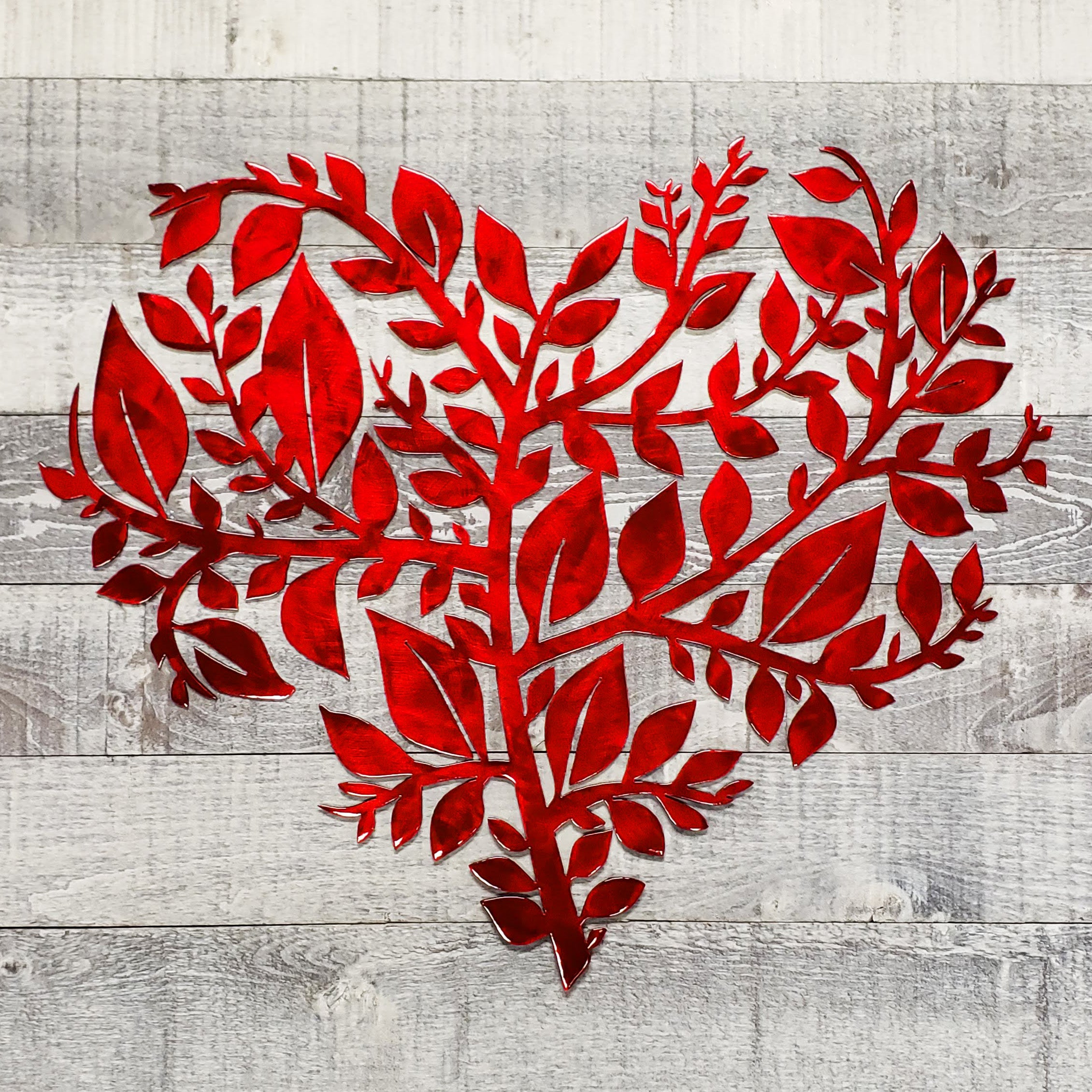 Red leaf-shaped cutout on a wooden surface