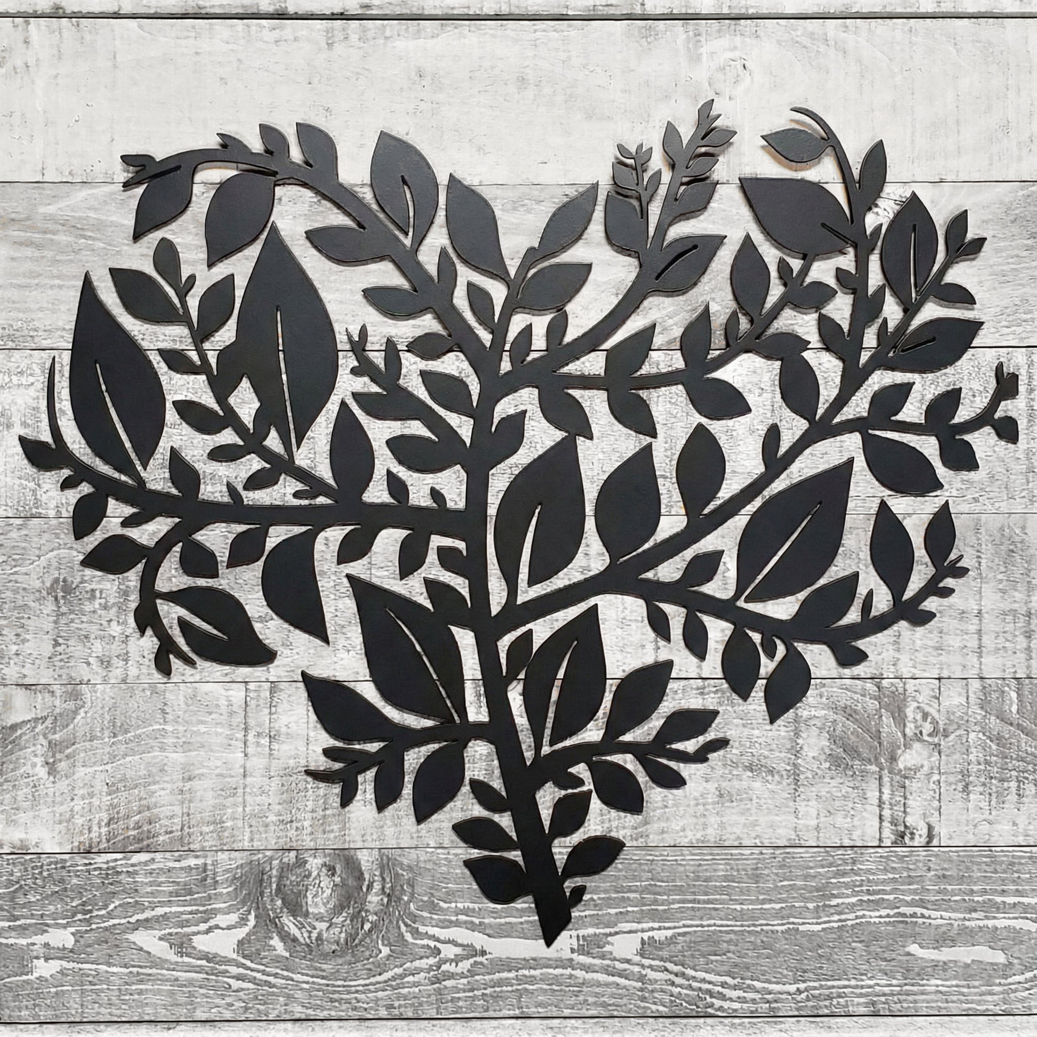 Black metal leaf design on a wooden background