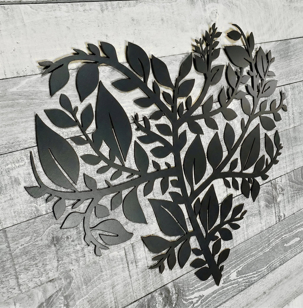 Metal leaves in the shape of a heart on a wooden surface