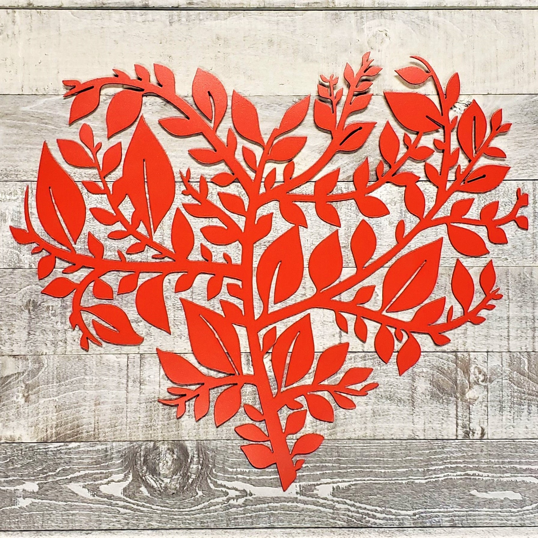 Red leaf-shaped cutout on a wooden surface
