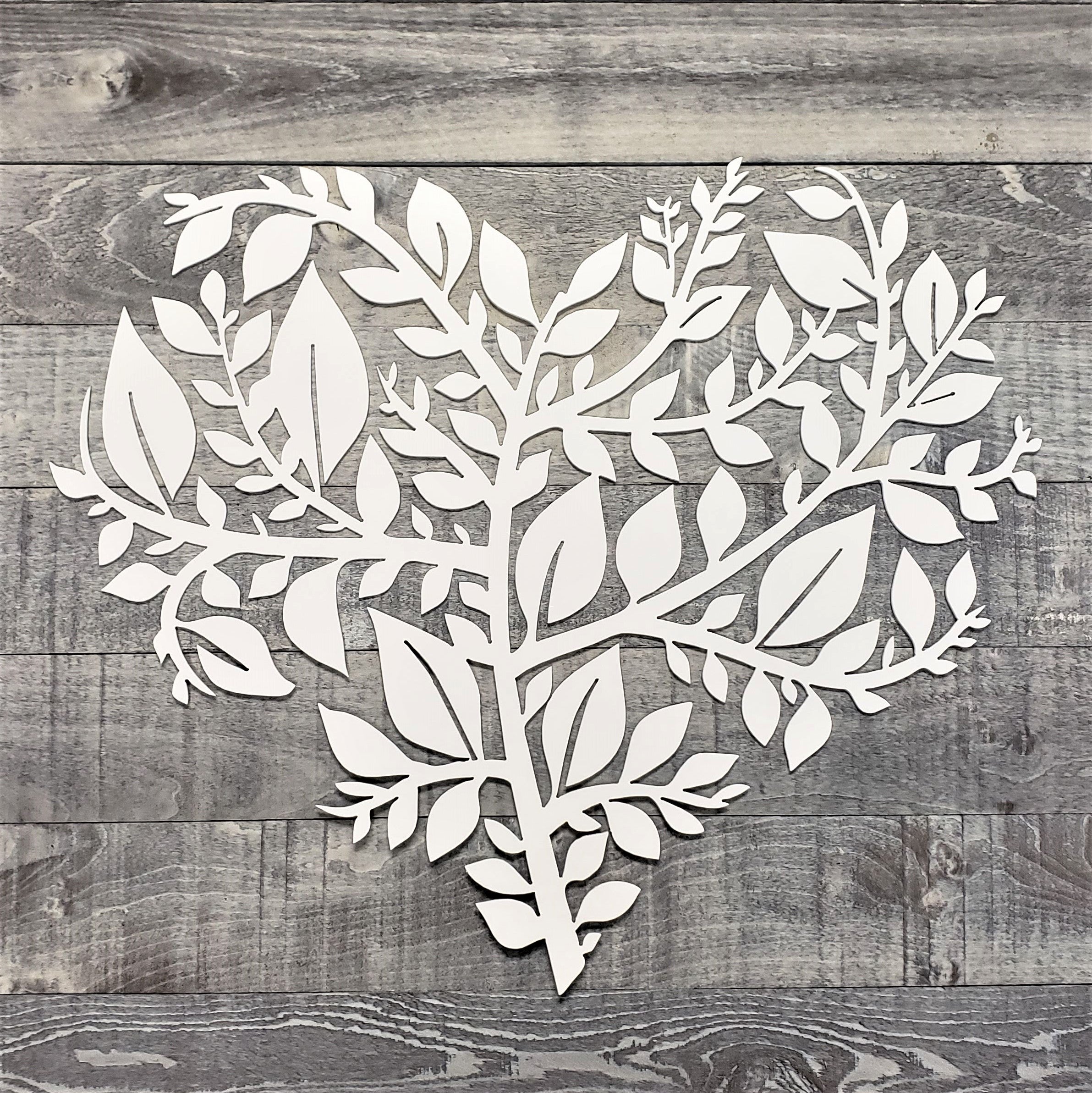 White leaf-shaped cutout on a wooden background