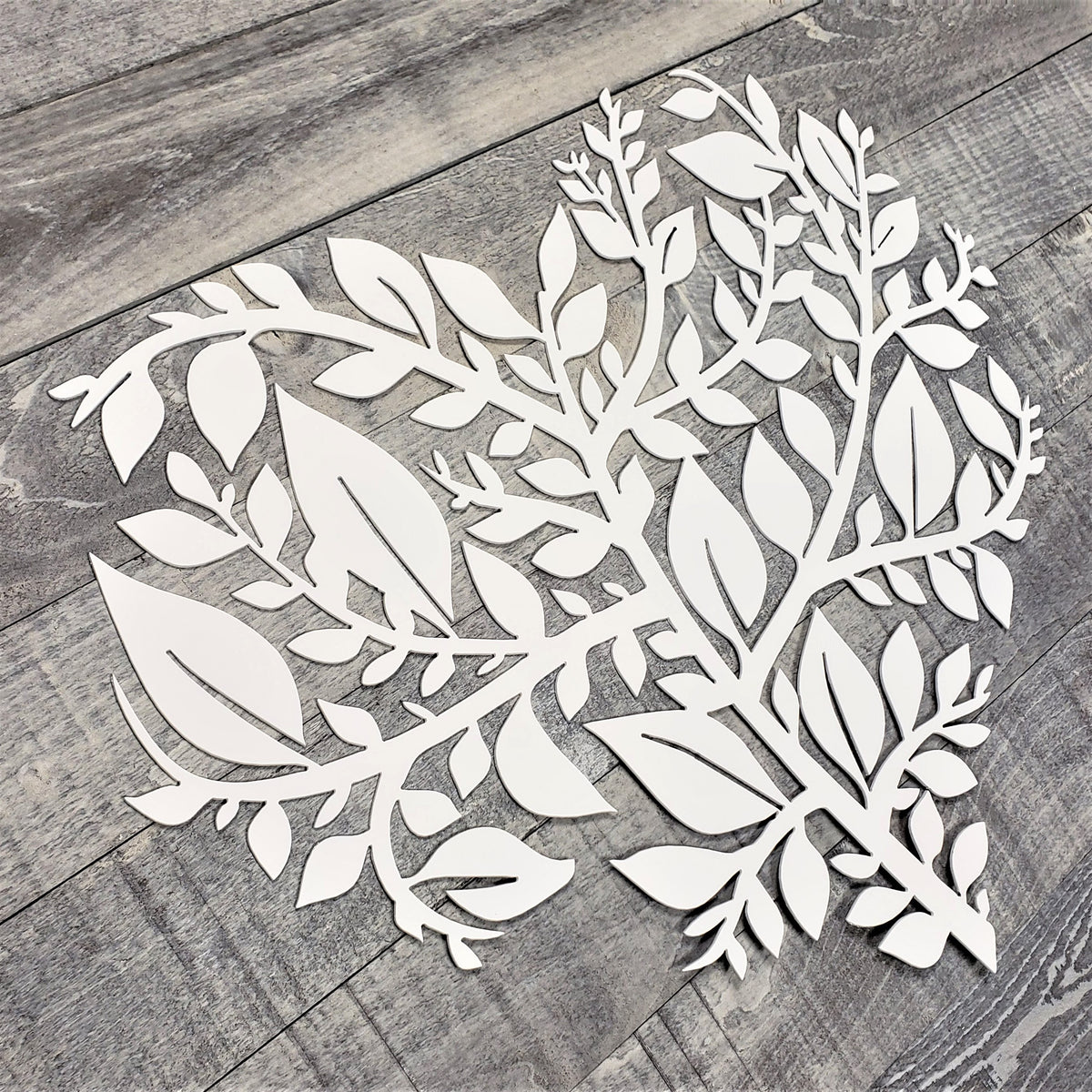 White leaf-shaped cutout on a wooden surface