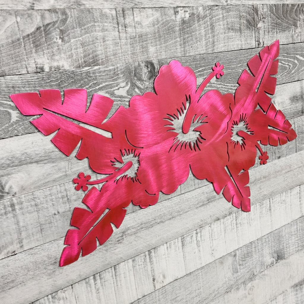 Pink metal floral wall art on a wooden background