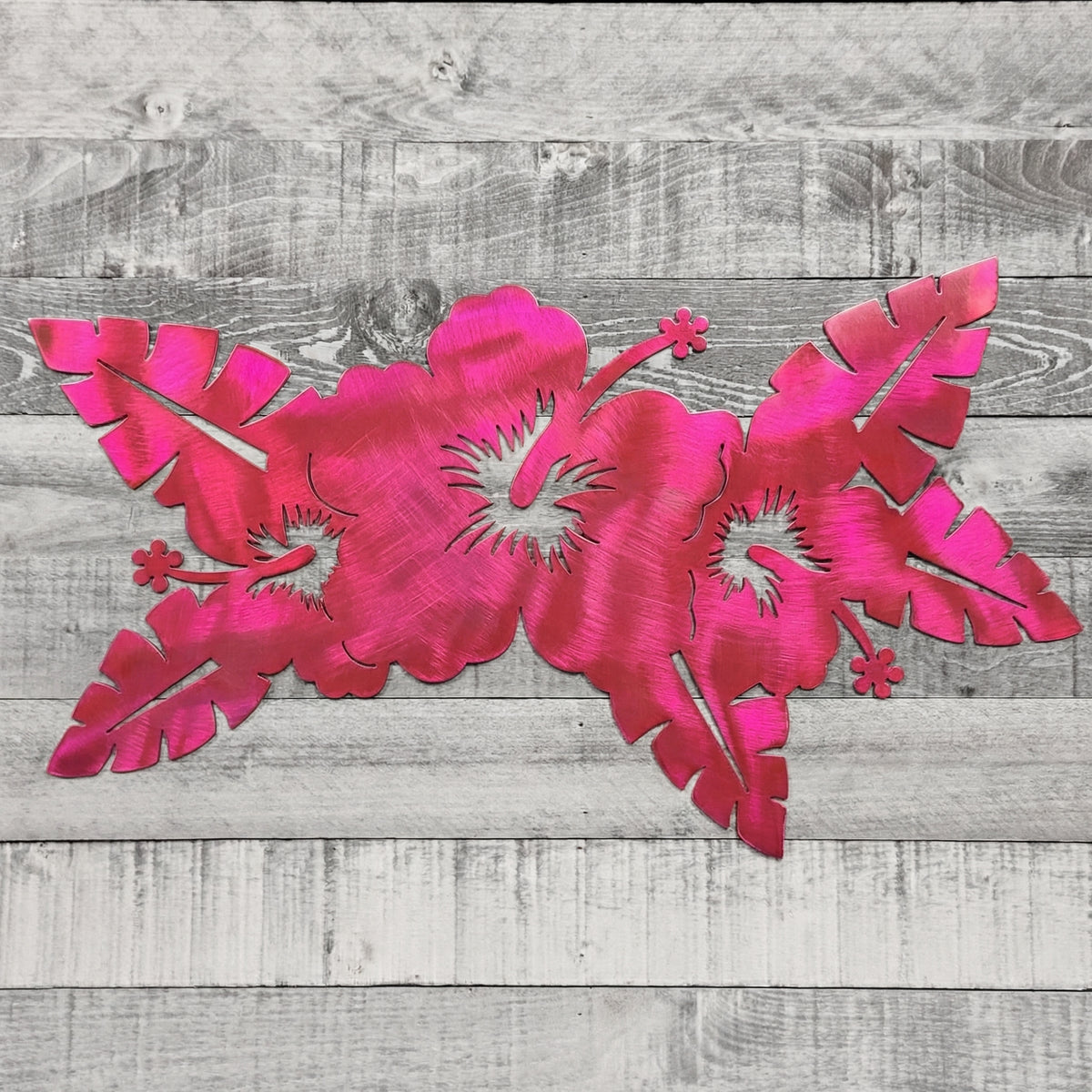 Decorative pink floral metal wall art on a wooden background