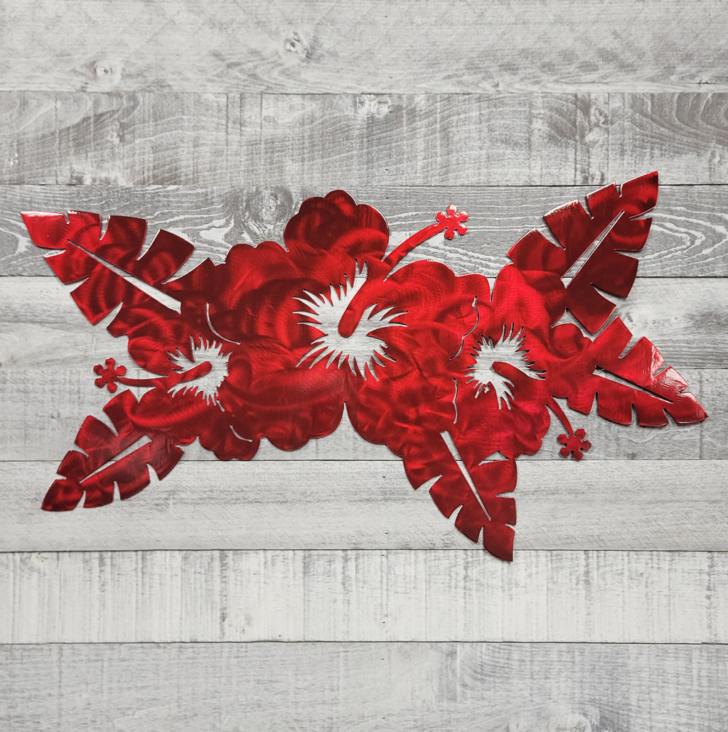 Red floral metal wall art on a wooden background