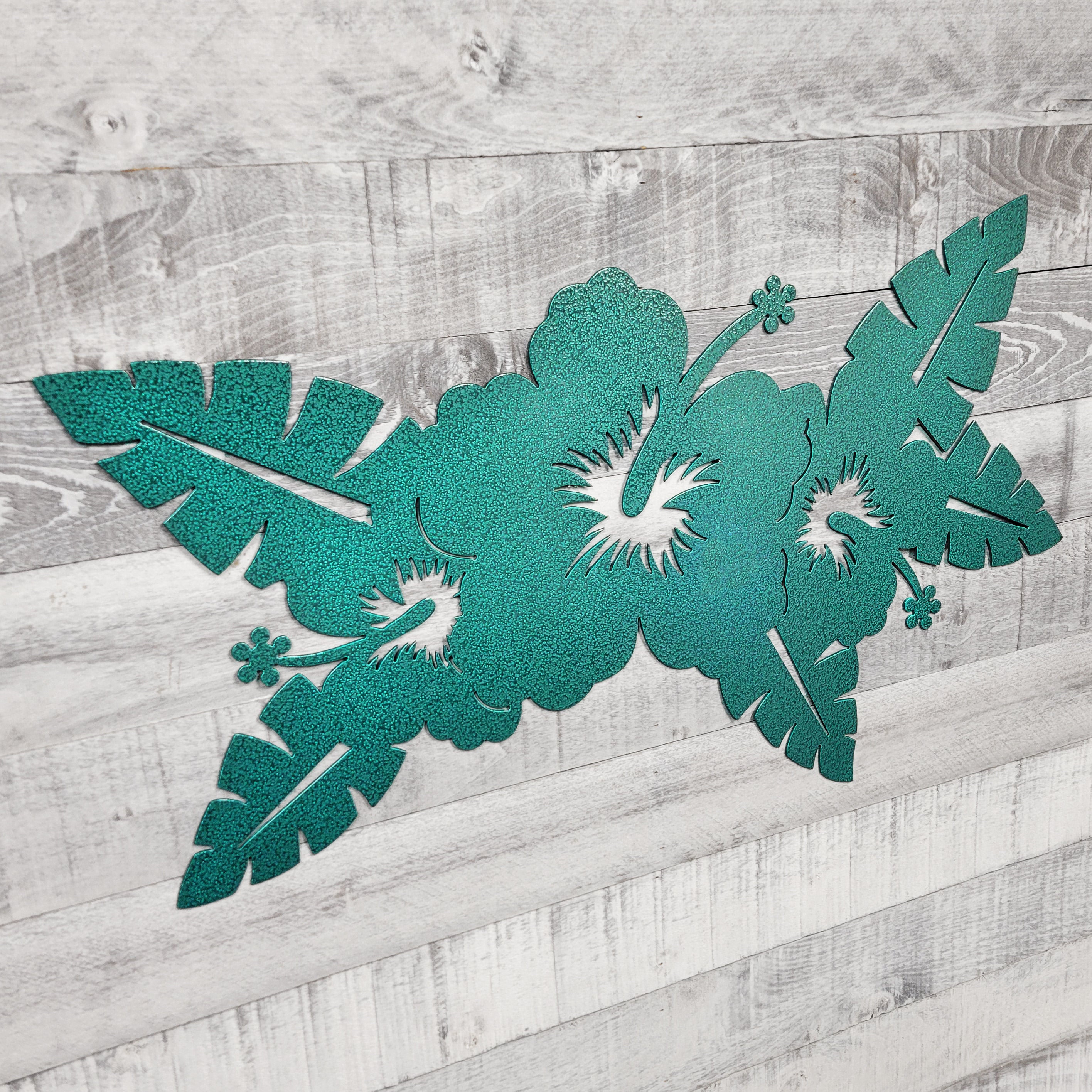 green floral metal wall art on a wooden surface