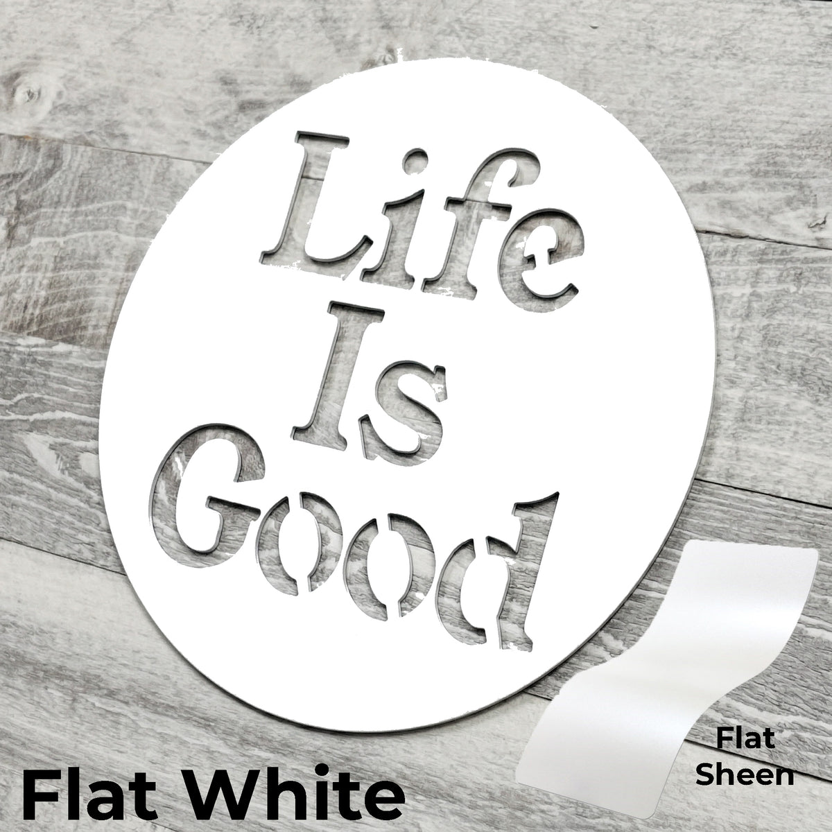 Round metal sign with 'Life Is Good' text on a wooden surface