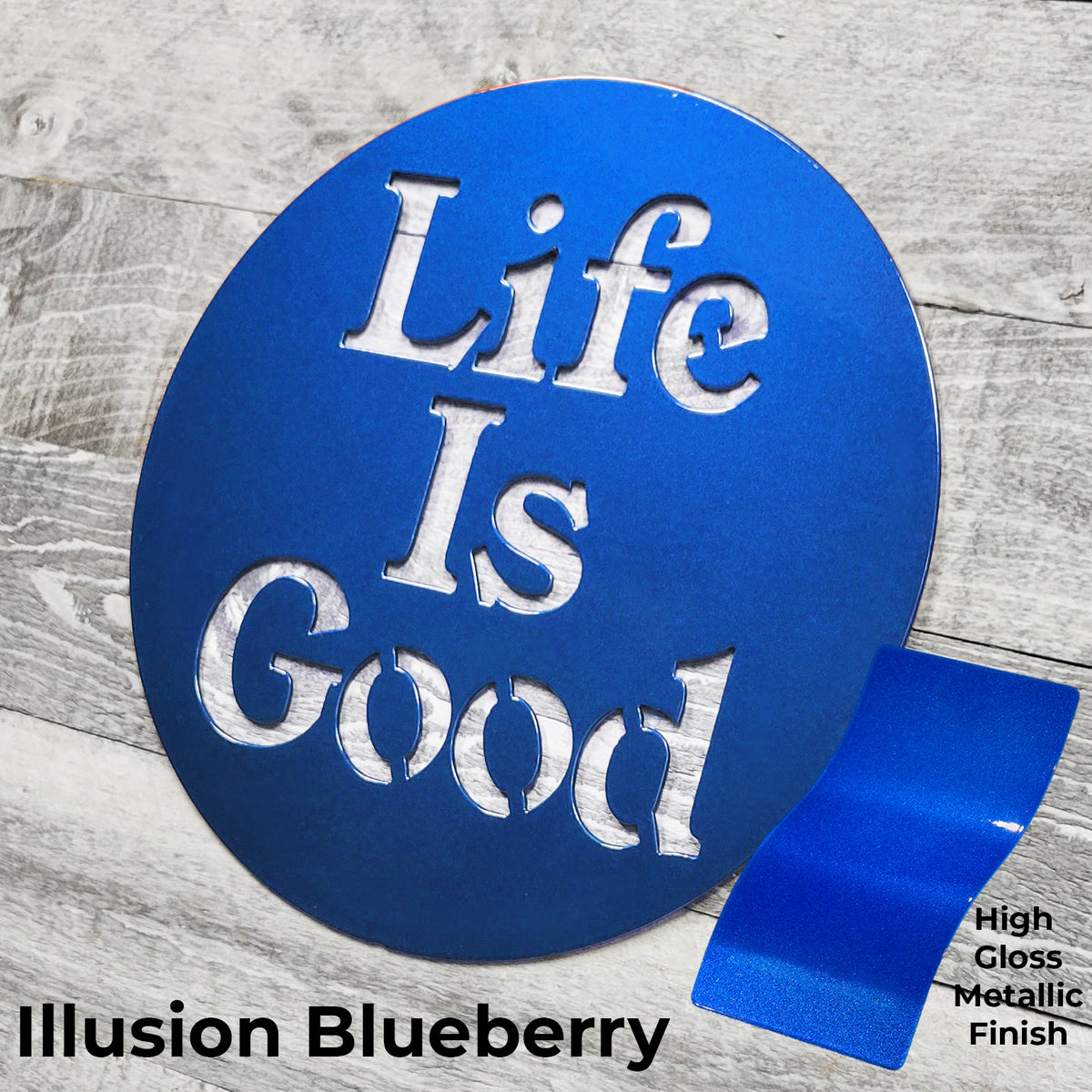 Blue circular sign with 'Life Is Good' text on a wooden surface