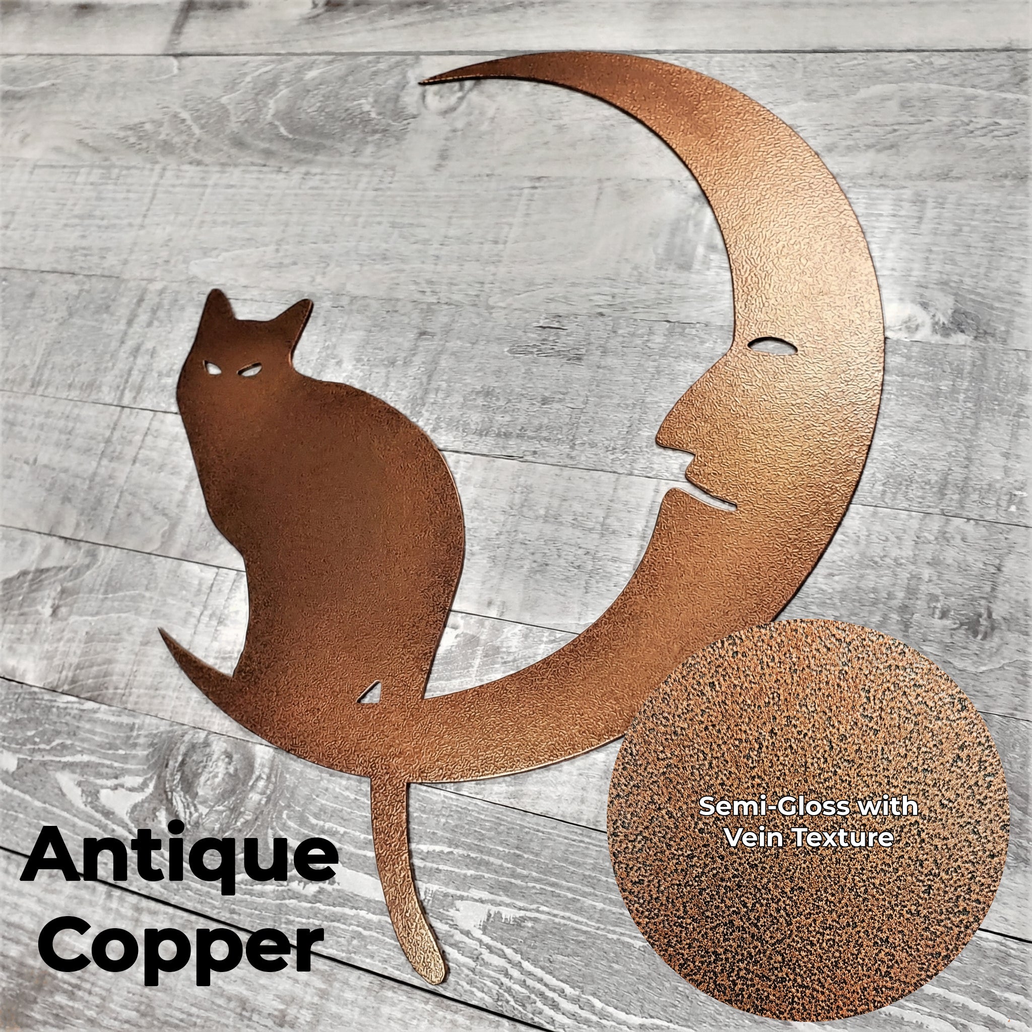 Decorative metal wall art with a cat on a crescent moon on a wooden background with a close-up of the Antique Copper color finish.
