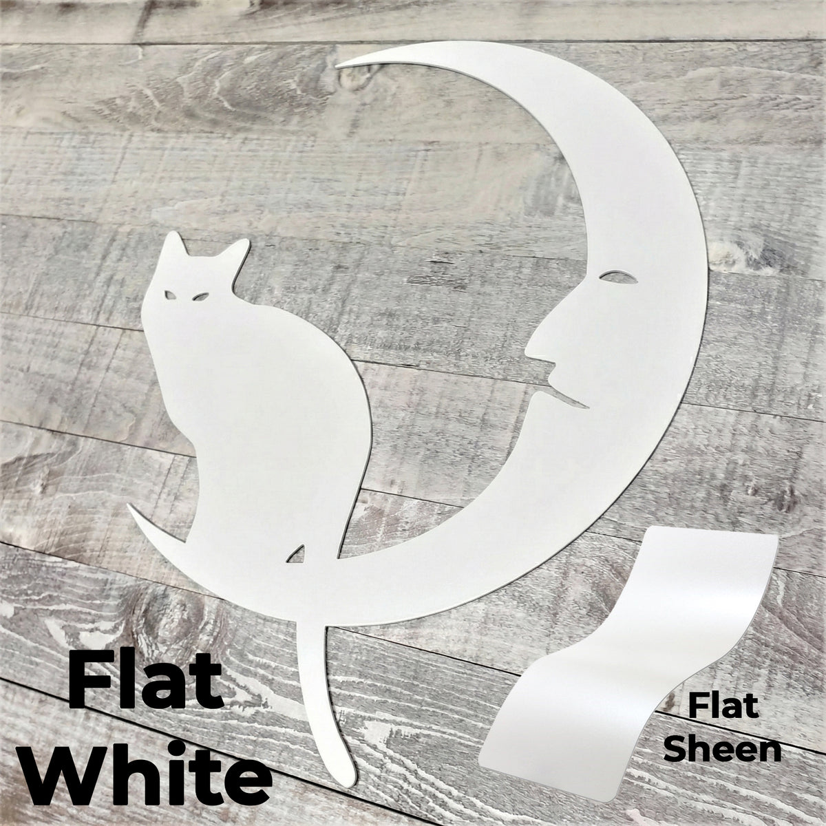 White cat and moon cutout on a wooden surface