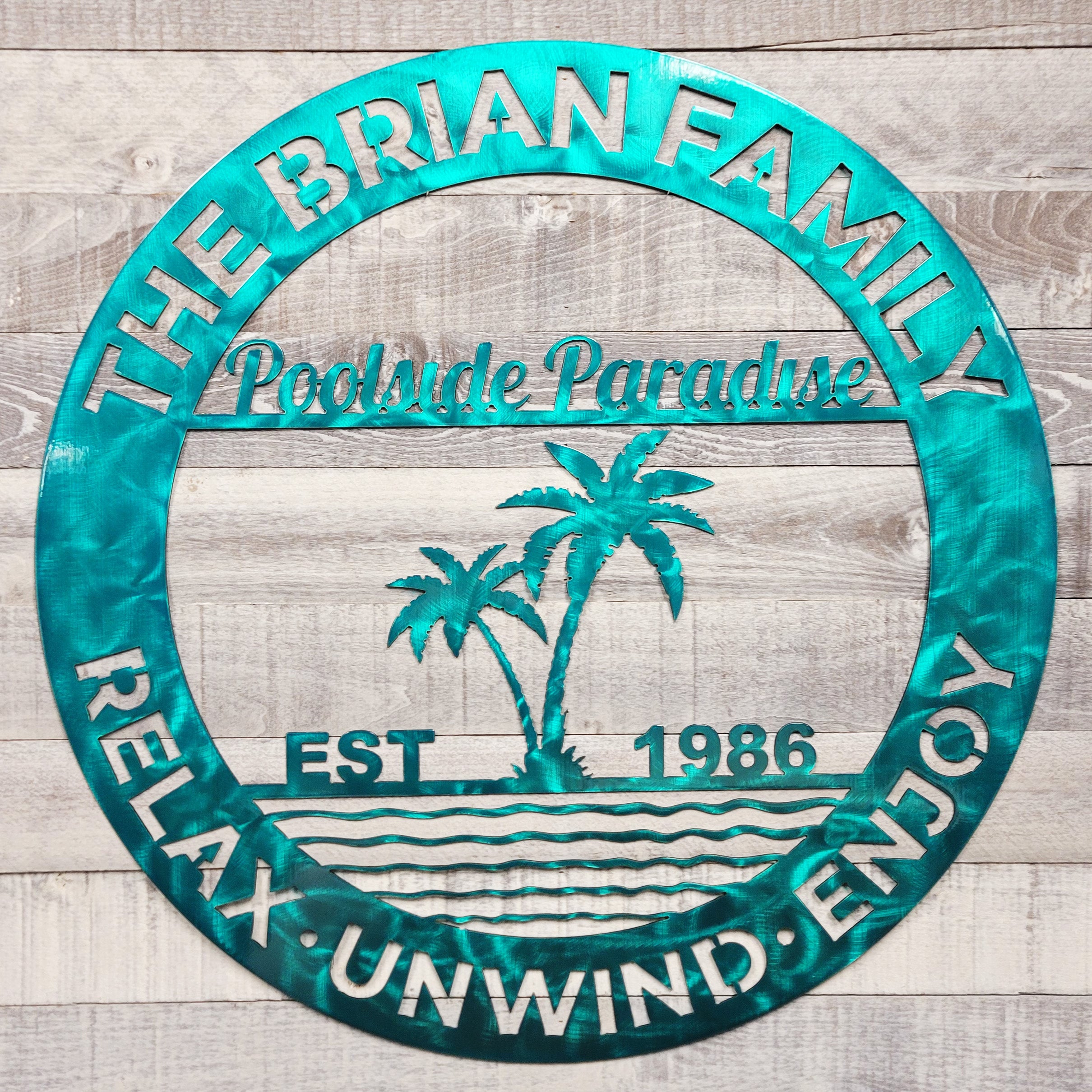 Decorative metal poolside paradise wall art design on a wooden background