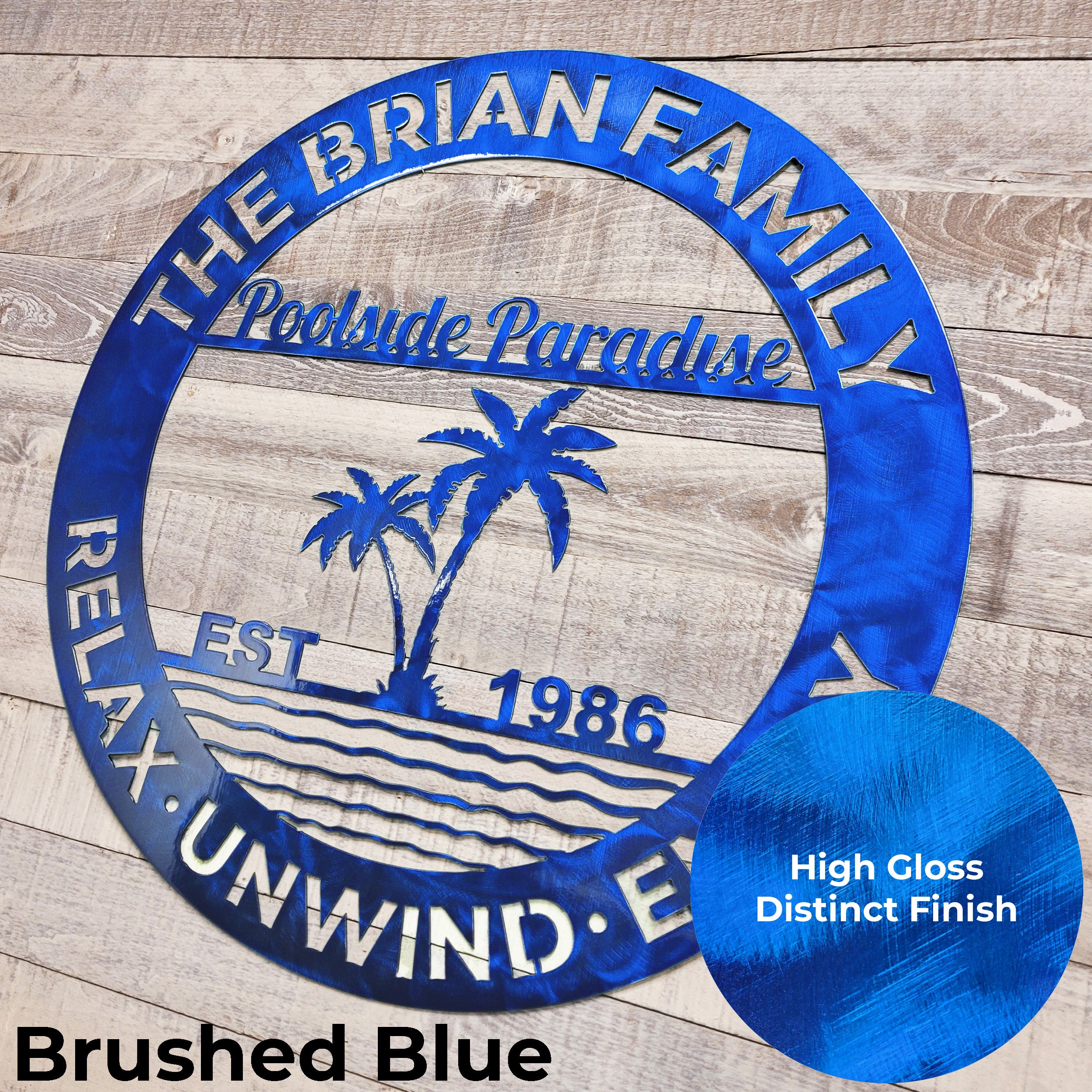 Blue circular poolside paradise metal wall art on a wooden background.