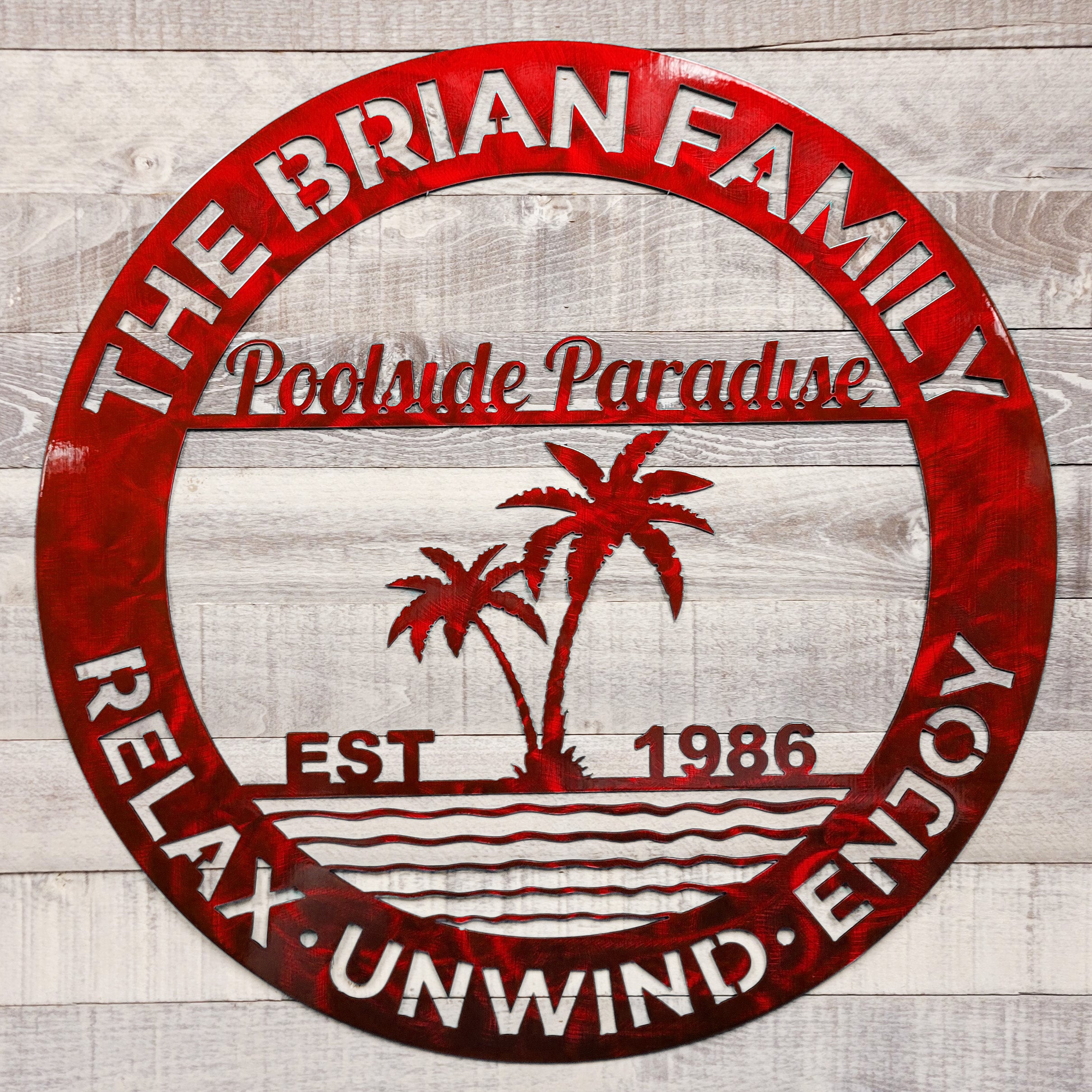 Decorative poolside paradise metal wall art on a wooden background with relax unwind enjoy