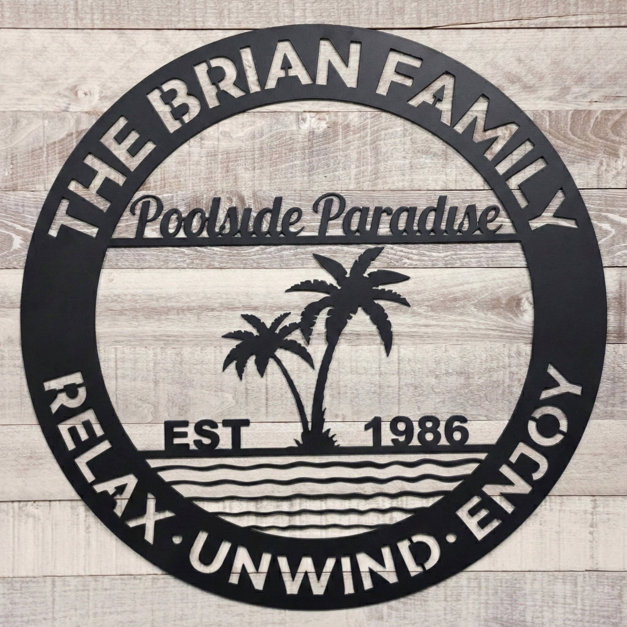Decorative metal poolside paradise sign on a wooden background