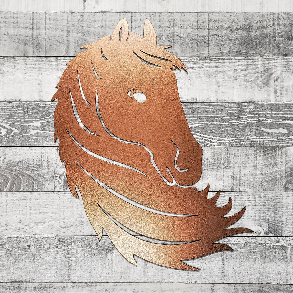 Metallic horse head wall art on a wooden background