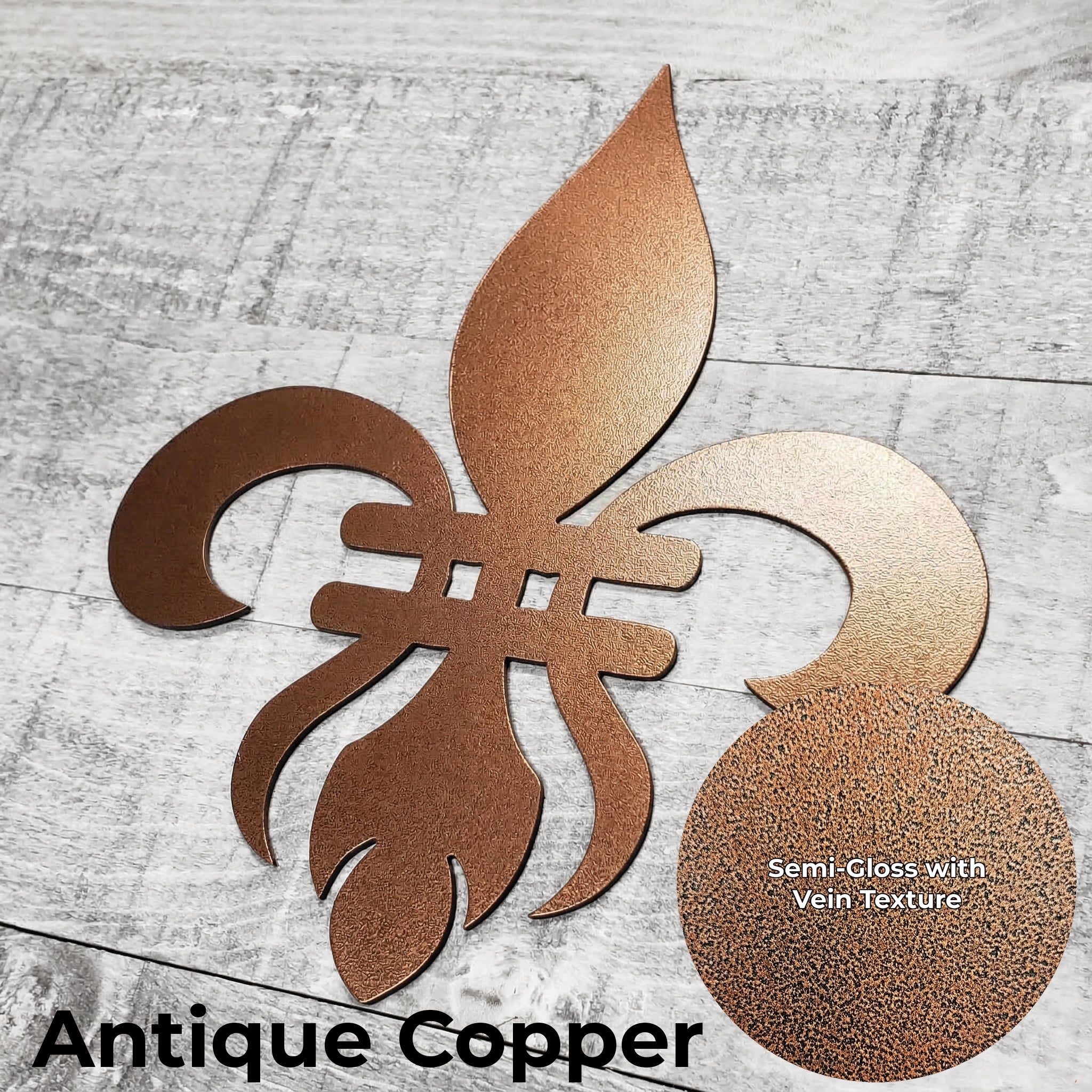 Decorative copper-colored metal fleur-de-lis on a wooden background with a close-up of the color finish