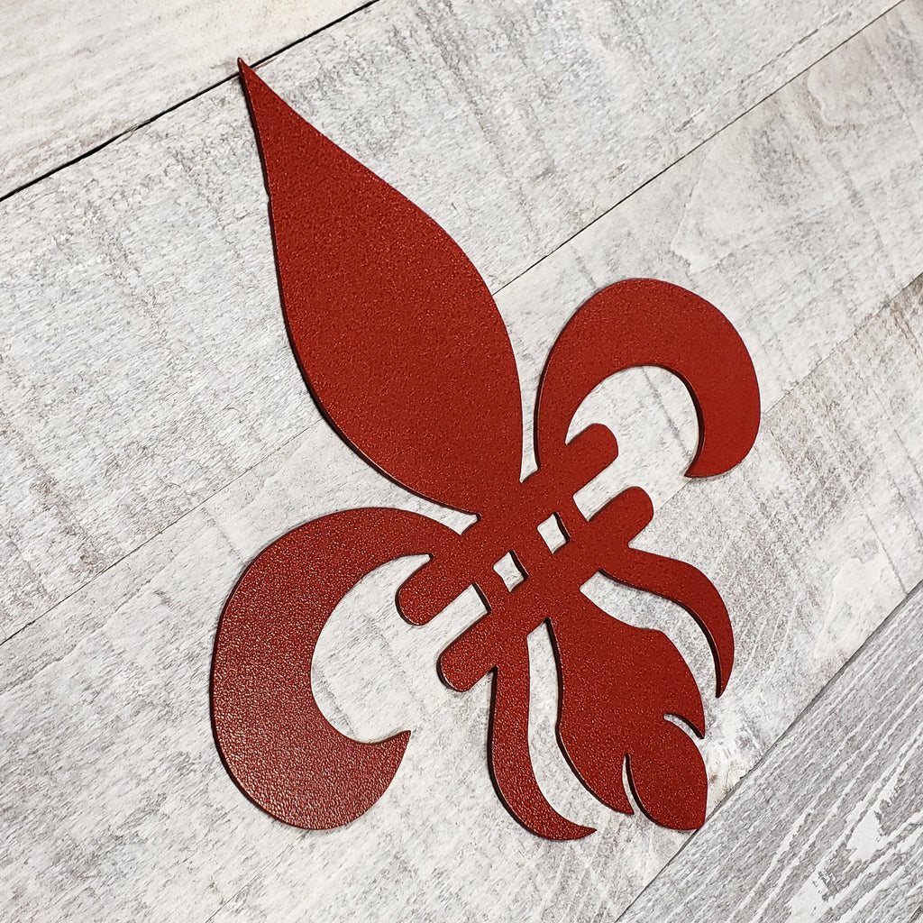 Decorative red metal fleur-de-lis on a wooden background