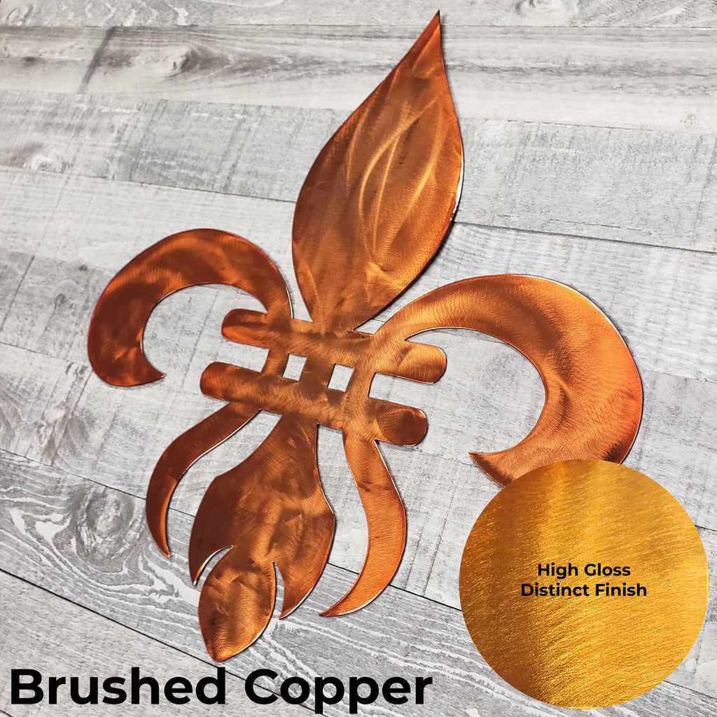 Decorative copper-colored metal fleur-de-lis on a wooden background with a close-up of the color finish