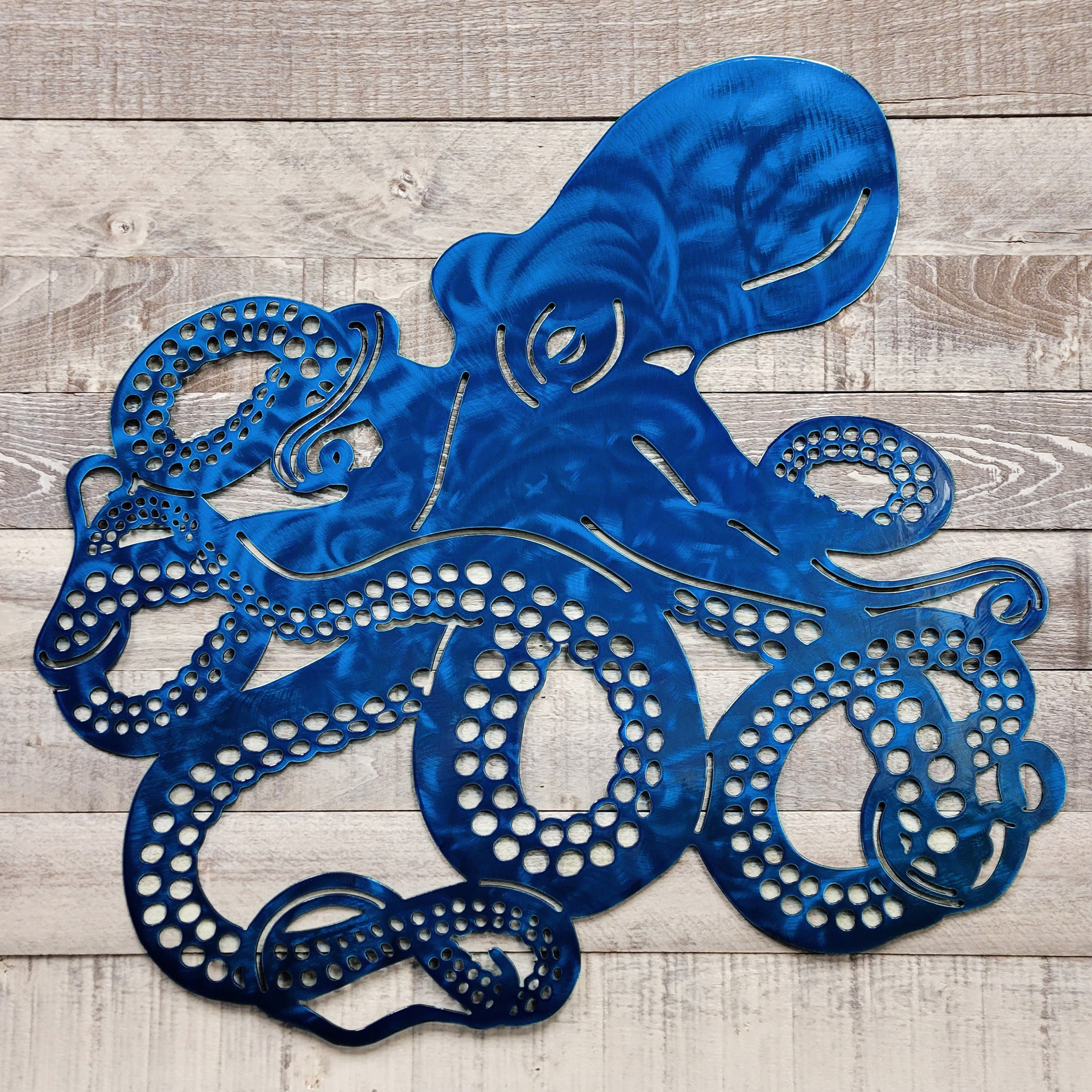 Blue metal octopus wall art on a wooden surface